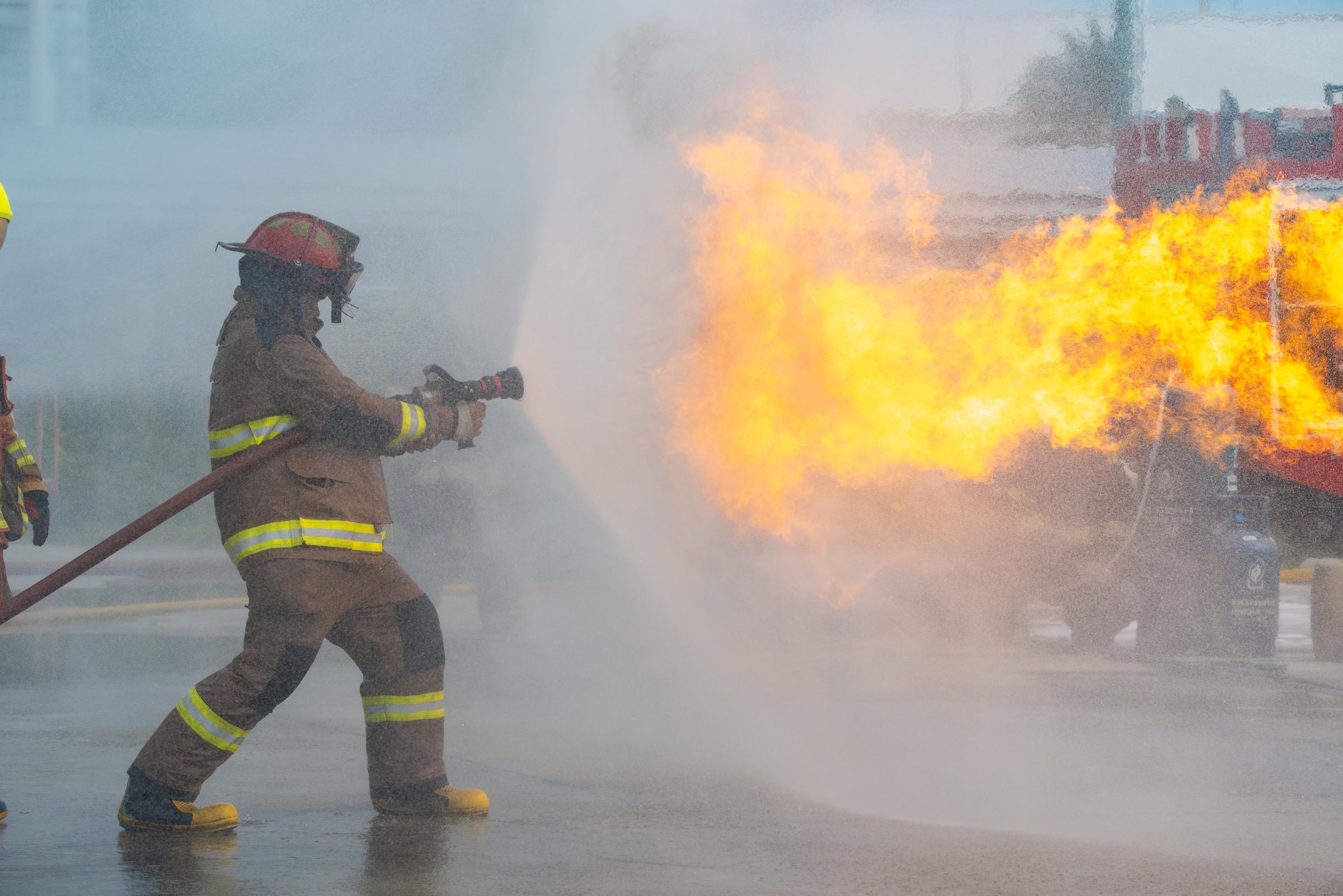 Un pompier arrosant une maison en feu I Photo d'illustration I Source : Getty Images