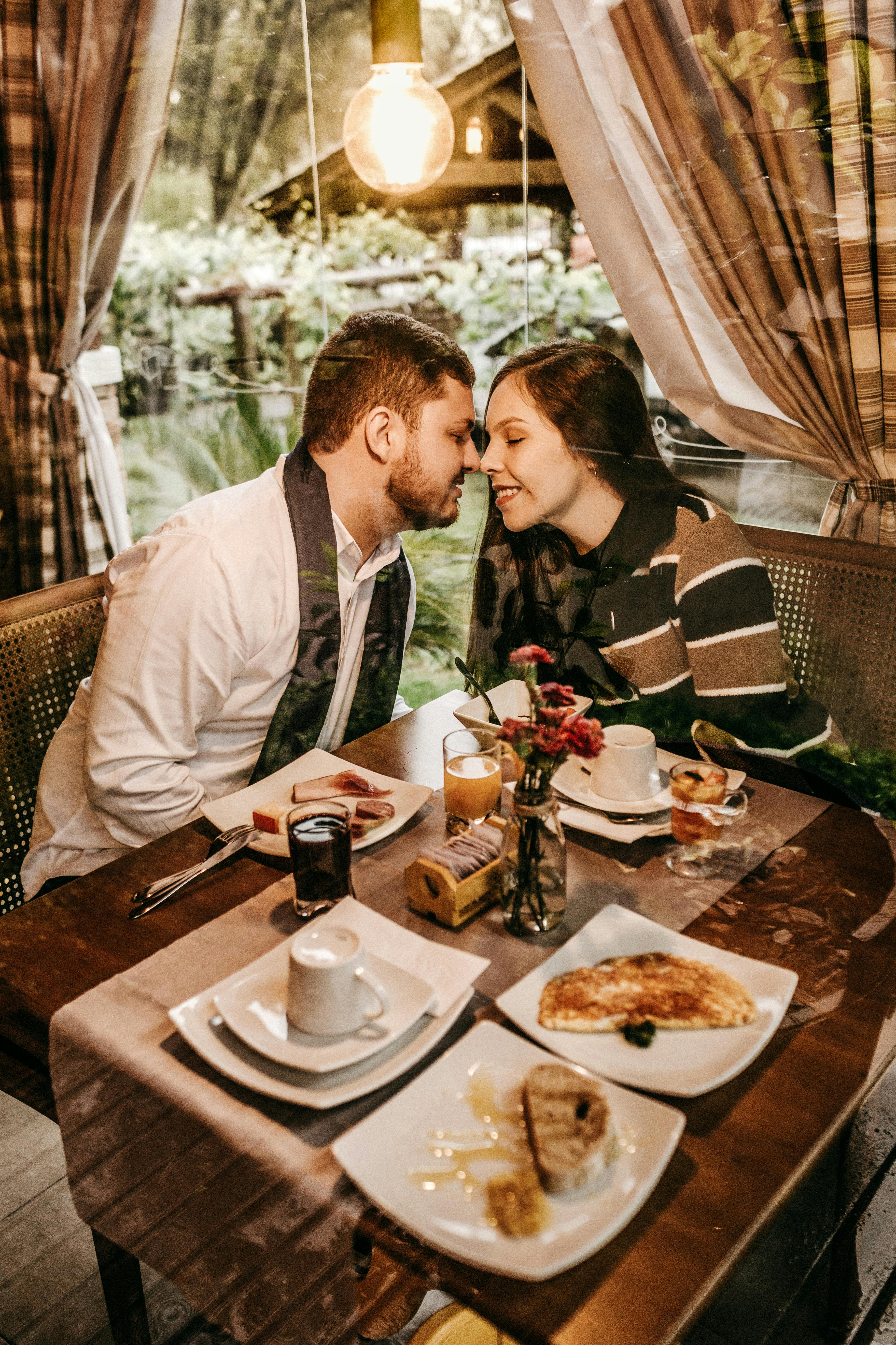 Un couple sur le point de s'embrasser dans un restaurant | Source : Pexels