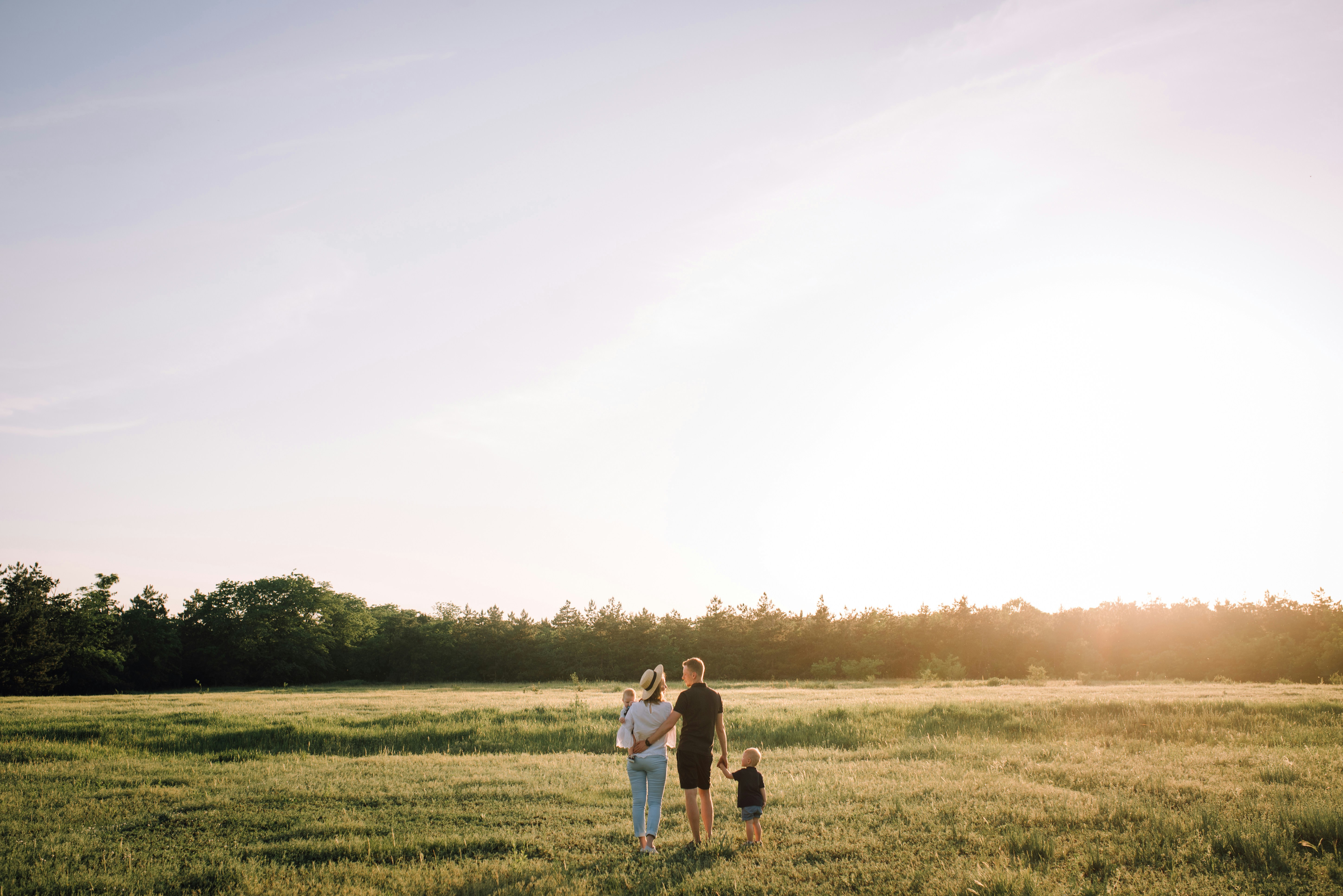 Famille heureuse dans un champ | Source : Pexels