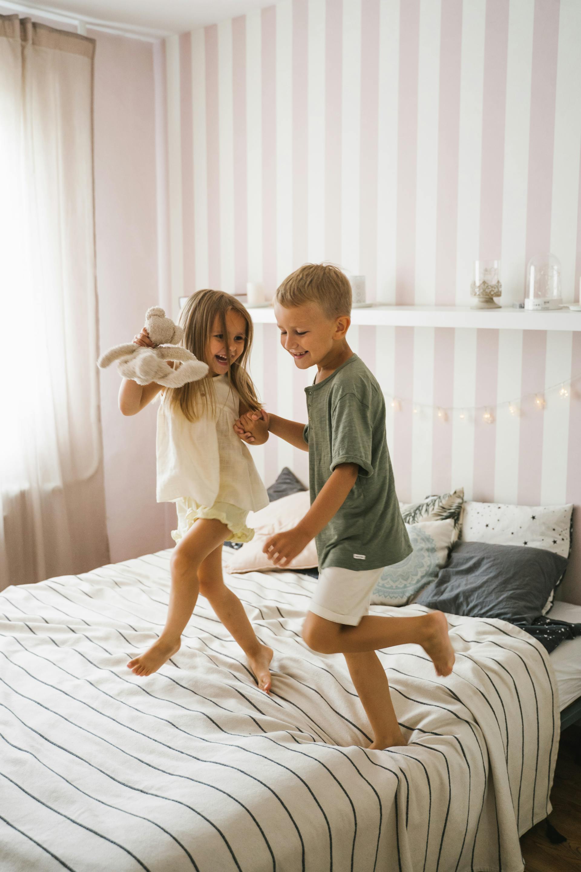 Des enfants heureux qui dansent sur le lit | Source : Pexels