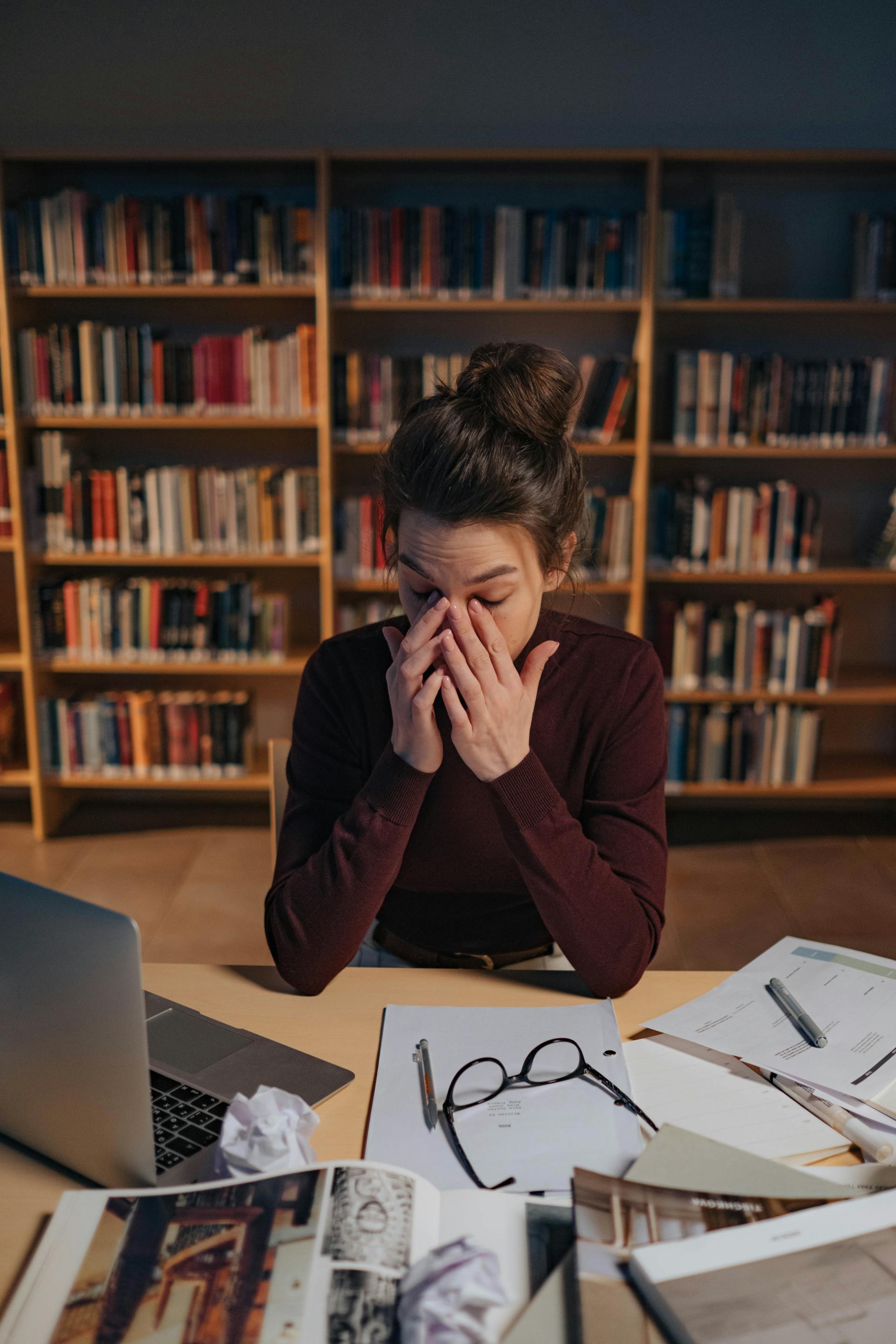 Une femme fatiguée travaillant dans une bibliothèque | Source : Pexels