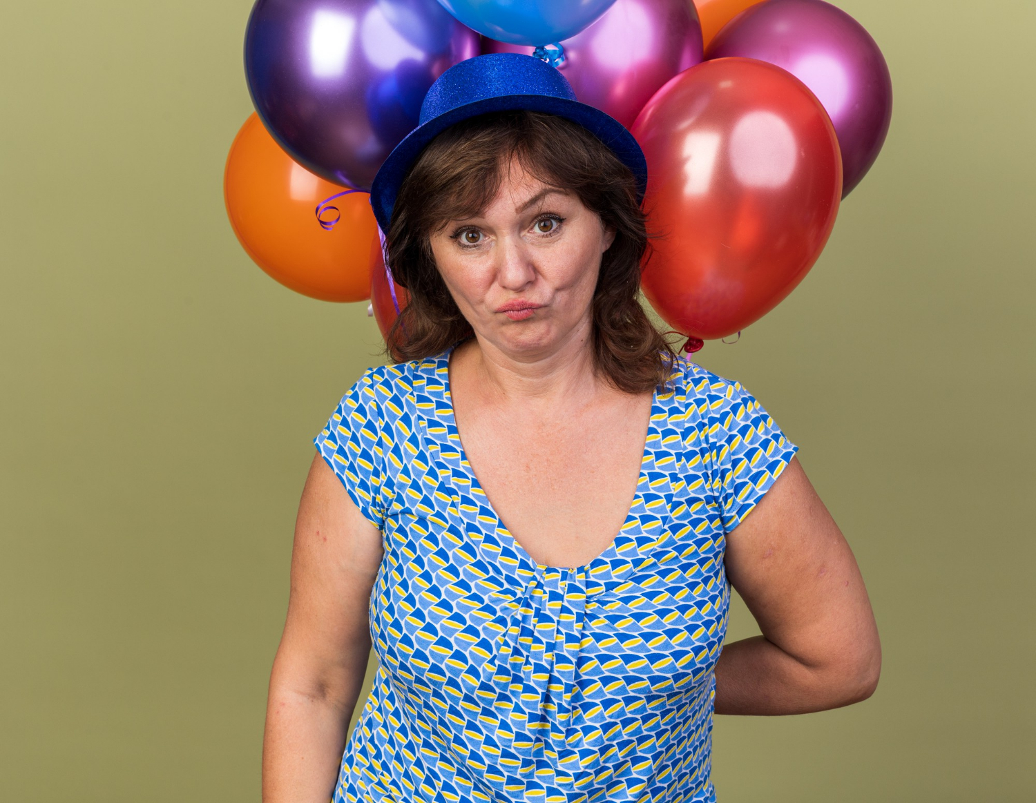 Une femme stupéfaite tenant des ballons colorés | Source : Freepik