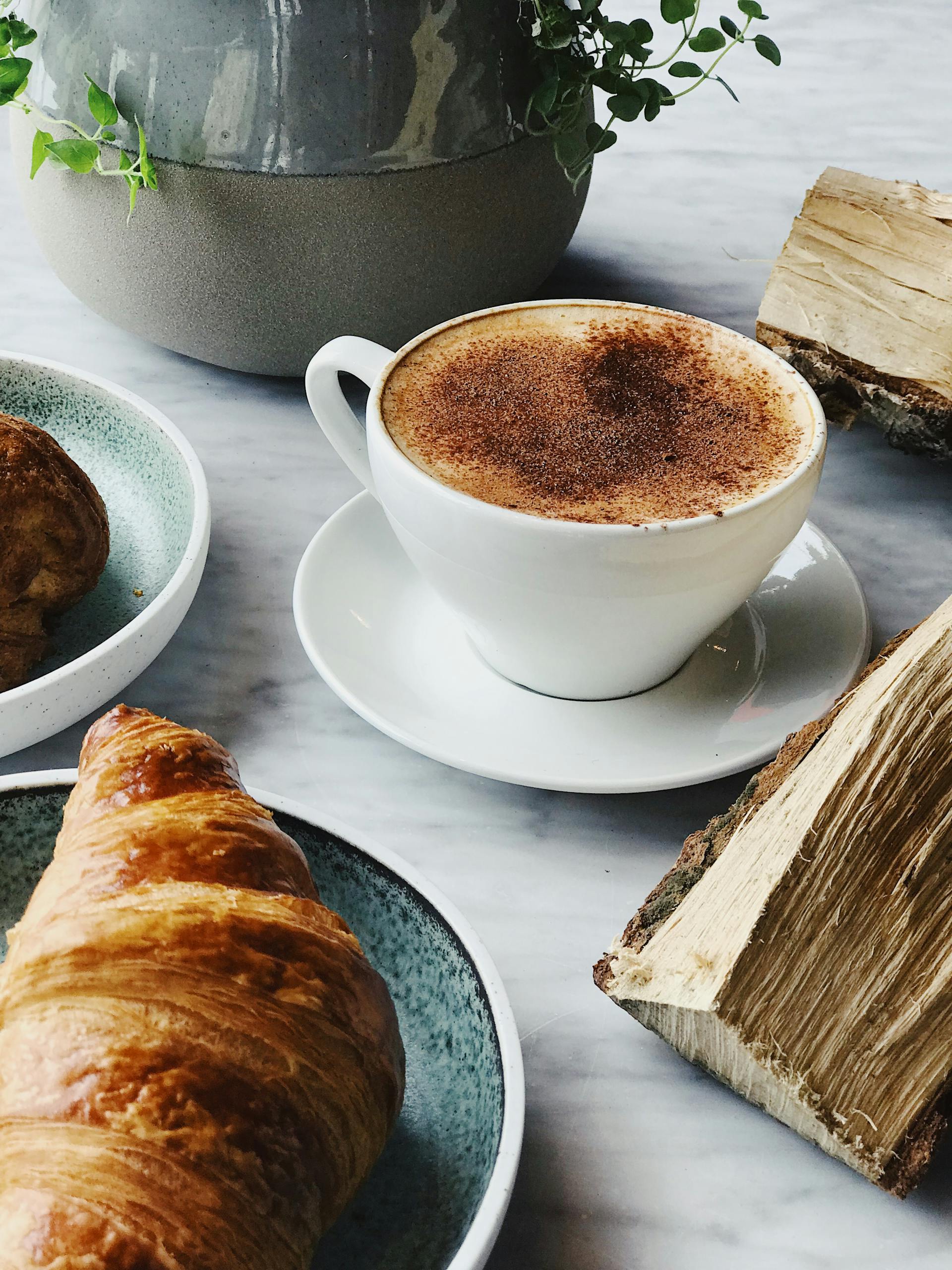Une tasse de café et un croissant posés sur une table | Source : Pexels