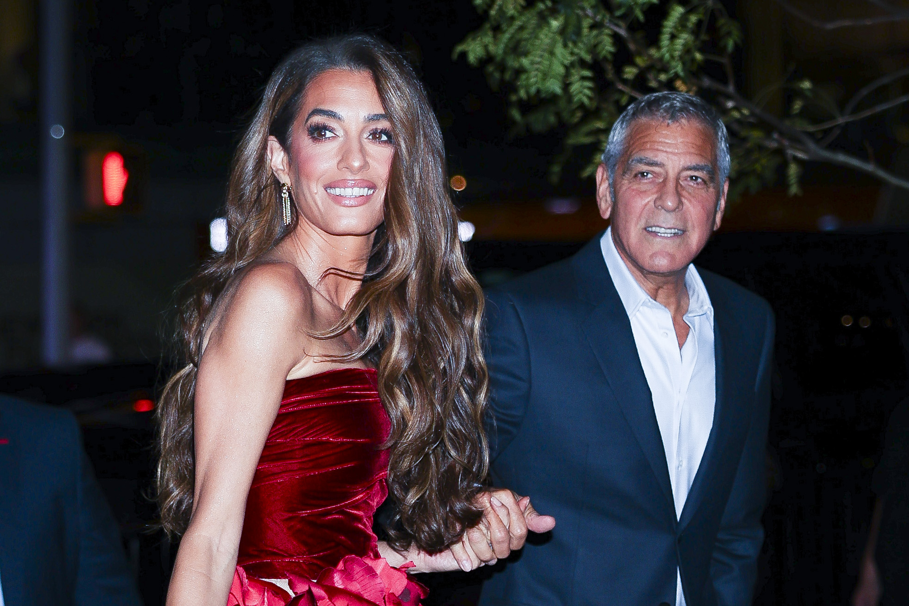 Souriant avec assurance, Amal Clooney rayonne aux côtés de George Clooney sous les lumières de la ville. Sa chevelure volumineuse et sa robe éclatante volent la vedette avant même qu'ils n'atteignent le tapis rouge.