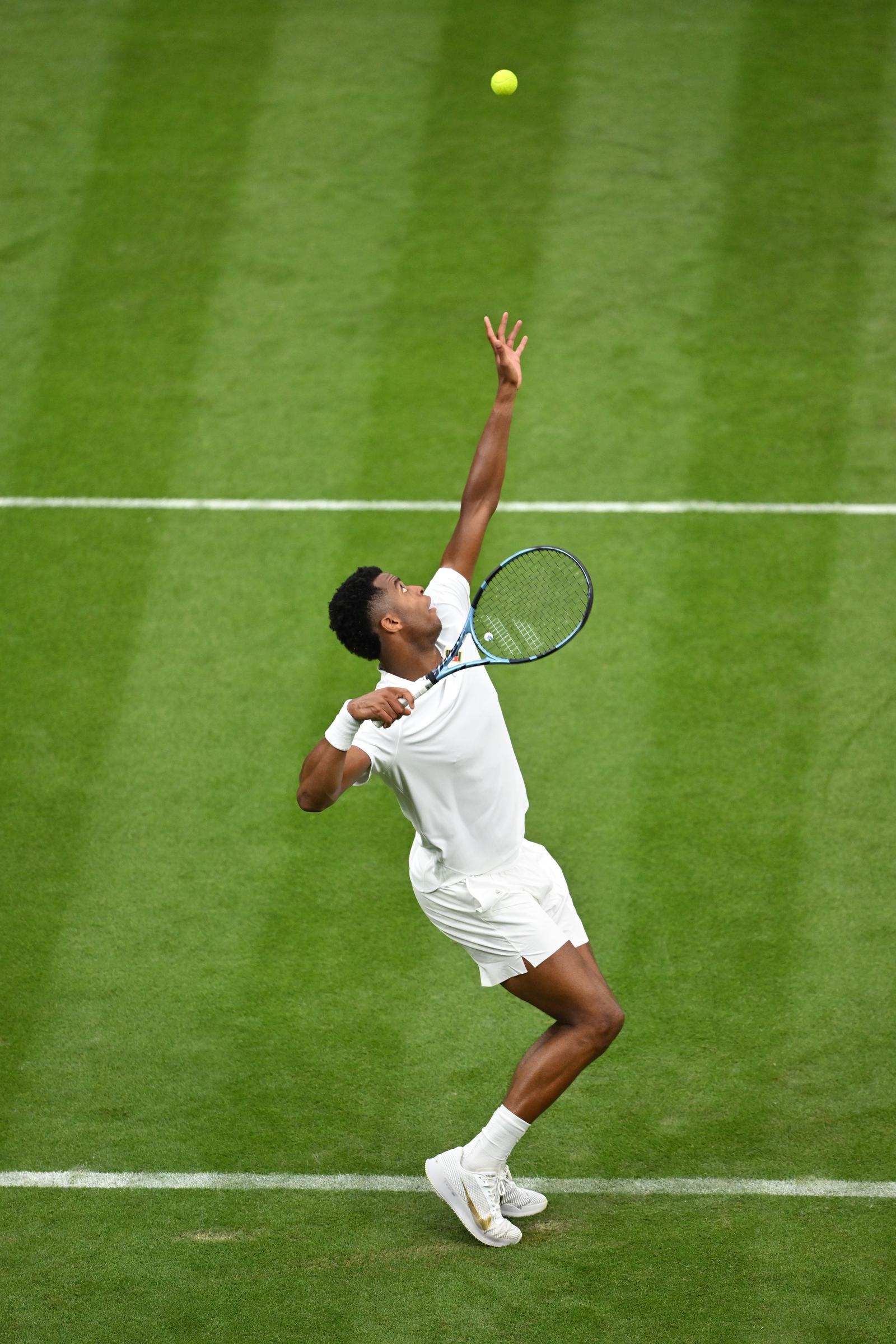 Giovanni Mpetshi Perricard (France) sert contre Taylor Fritz (États-Unis) lors du match du premier tour du simple messieurs, le premier jour du tournoi de Wimbledon 2025, au All England Lawn Tennis and Croquet Club, le 30 juin 2025 à Londres, en Angleterre I Source : Getty Images