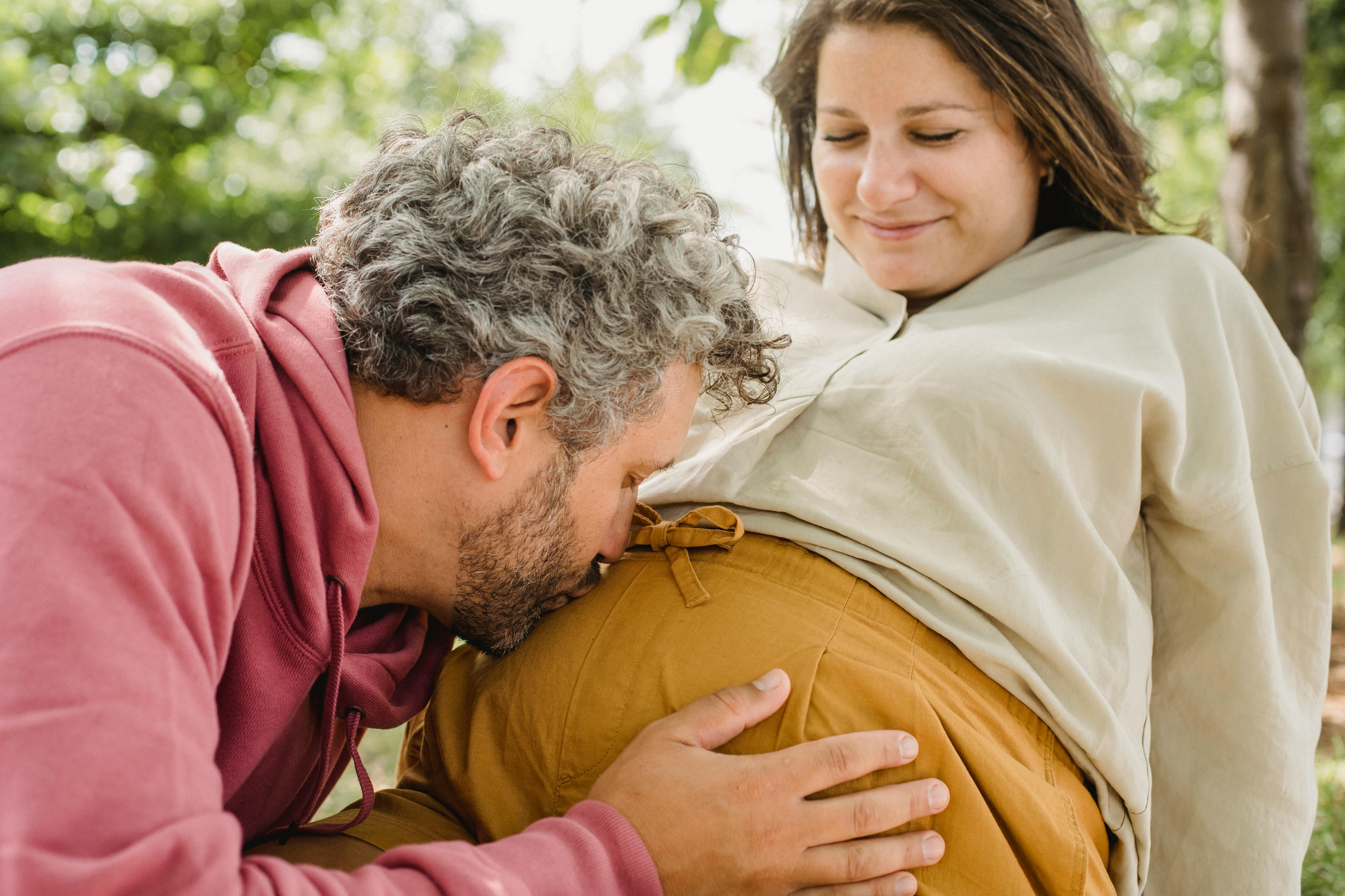 Un homme embrassant le ventre de sa femme enceinte | Source : Pexels