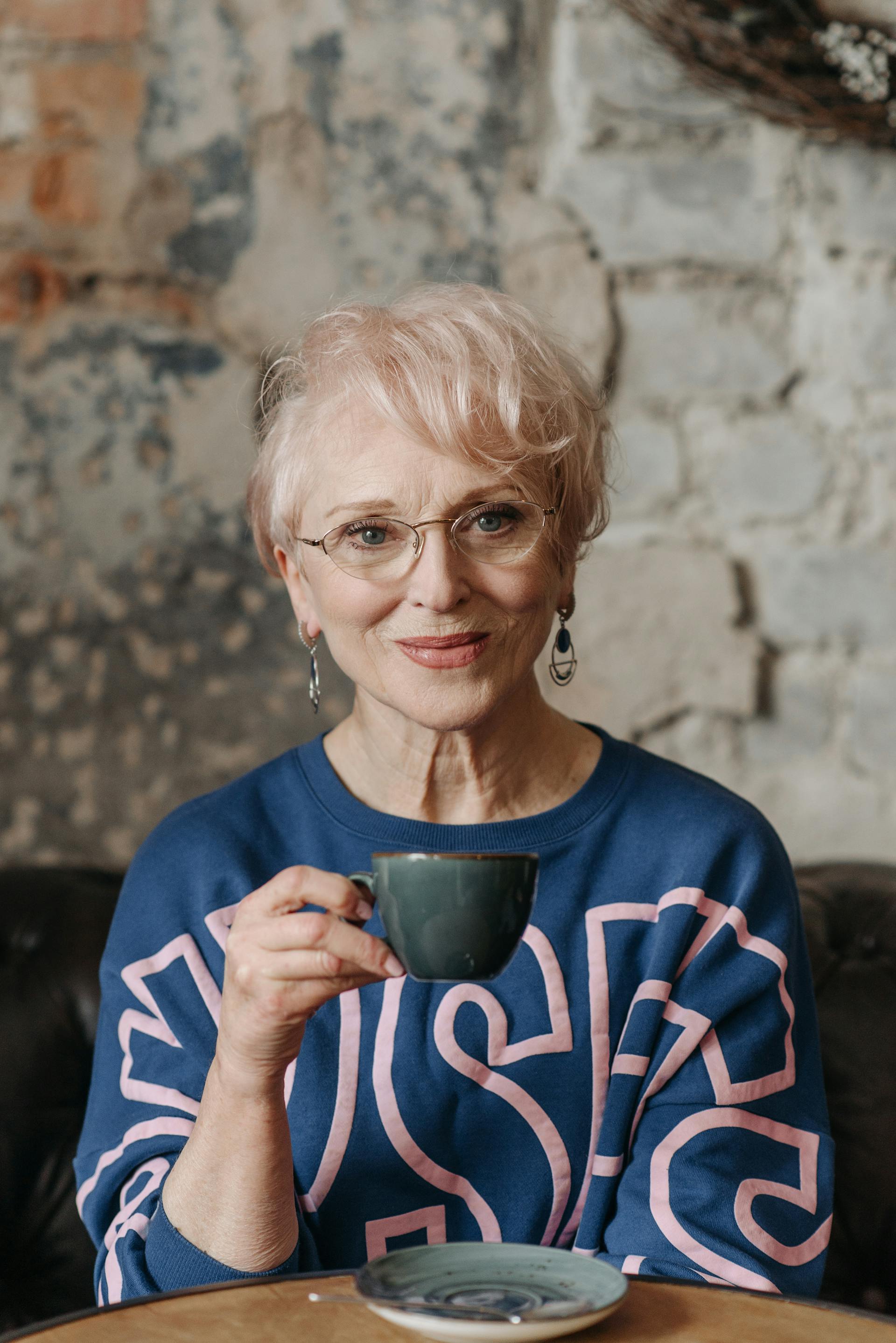 Une femme âgée souriante tenant une tasse de café | Source : Pexels