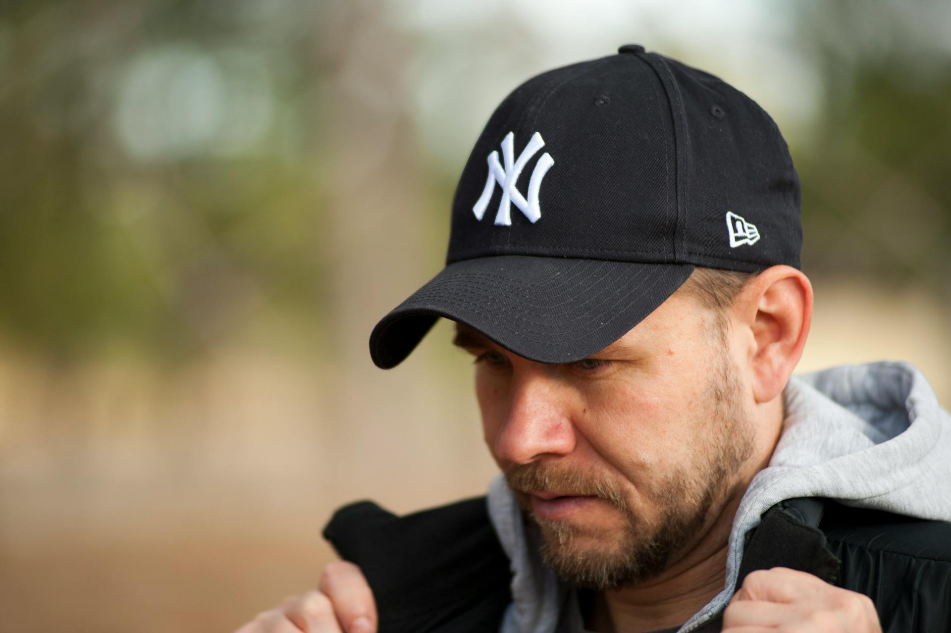 Homme portant un sweat à capuche et une casquette de baseball | Source : Pexels