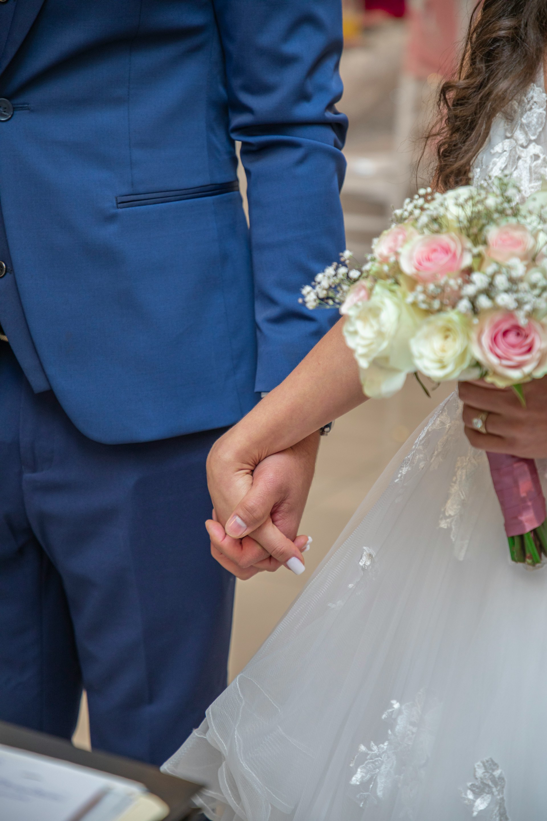 Une mariée tenant la main de son marié pendant leur cérémonie de mariage | Source : Unsplash