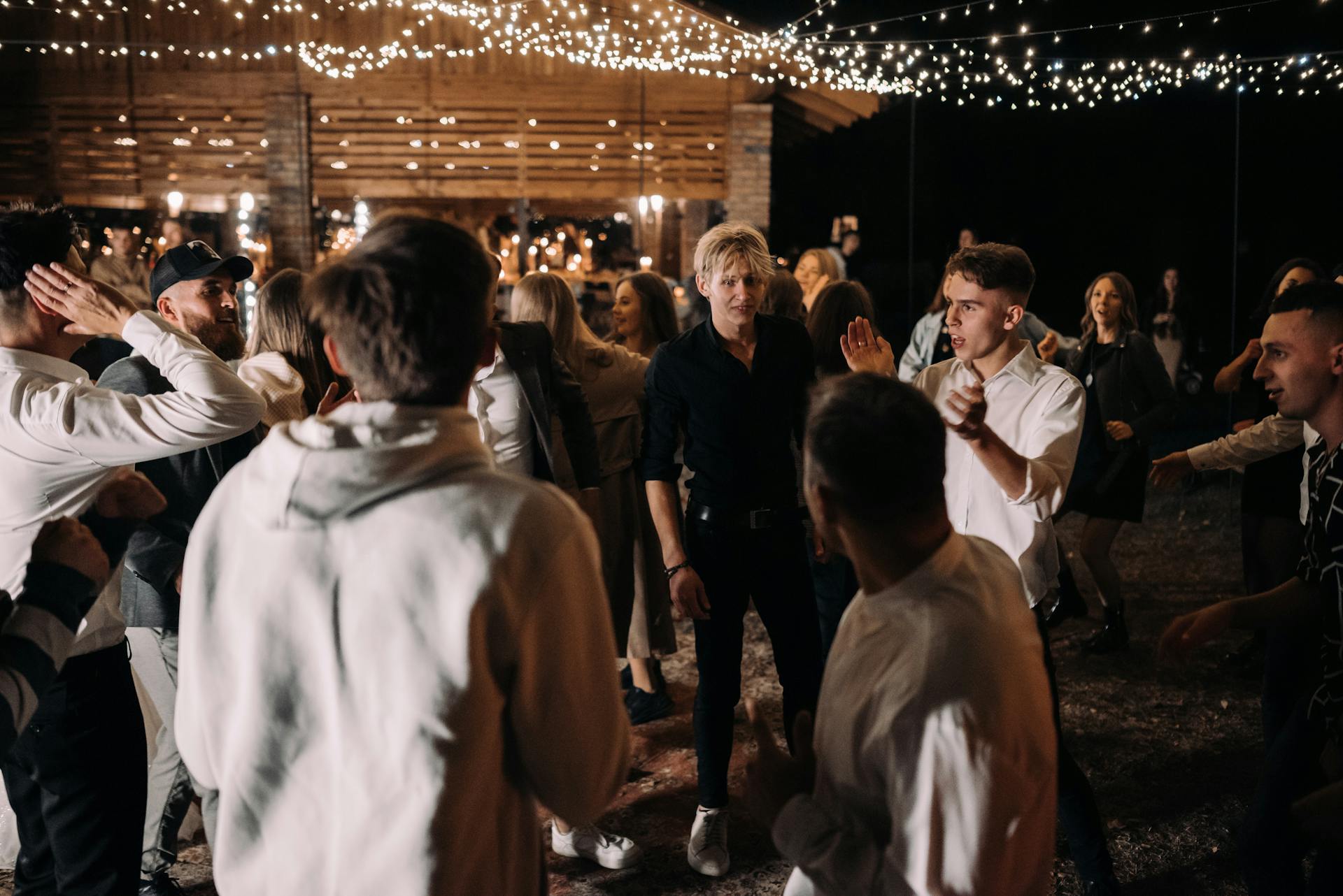 Un groupe de personnes dansant lors d'une fête avec des guirlandes lumineuses | Source : Pexels