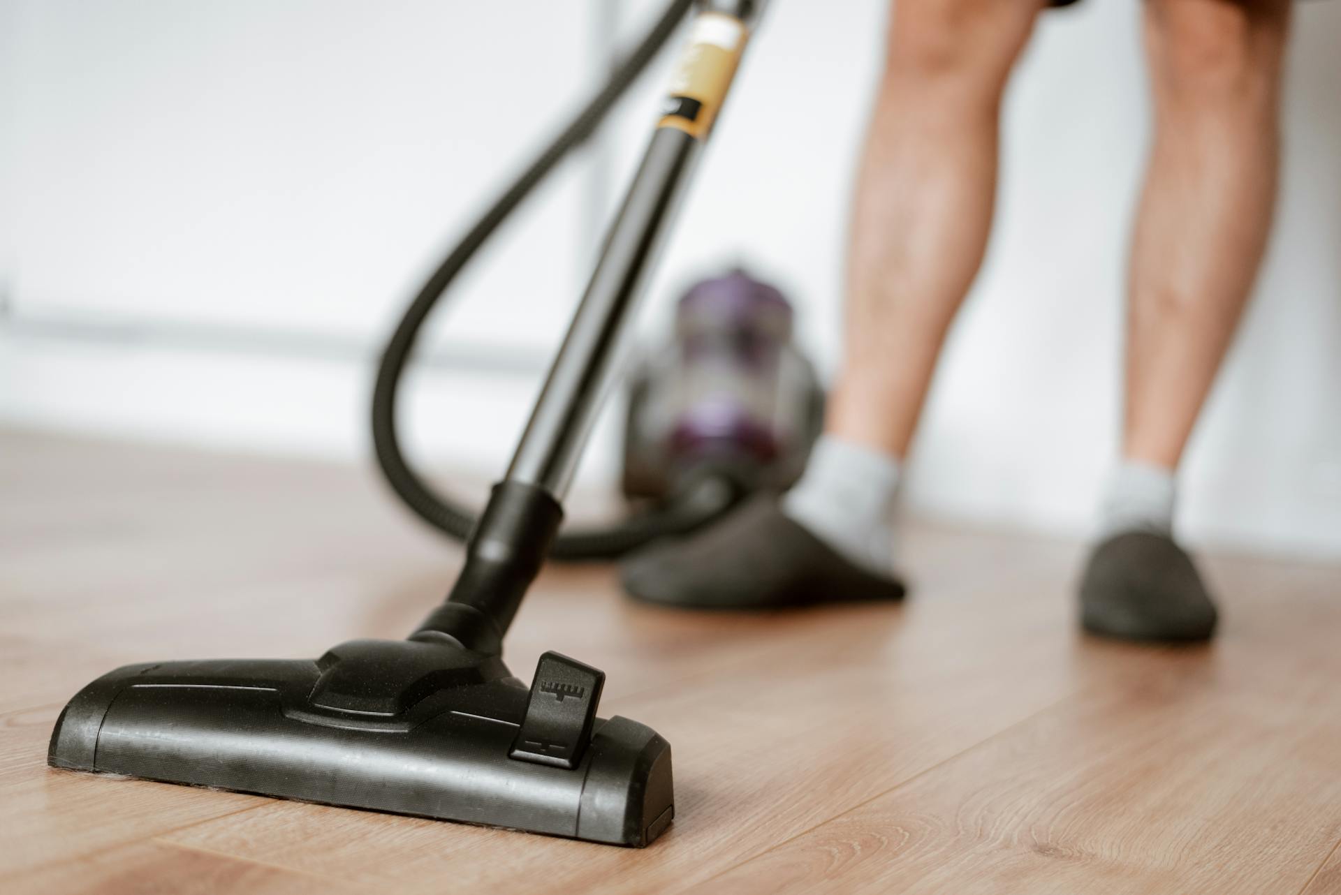 Un homme qui nettoie le sol avec un aspirateur | Source : Pexels