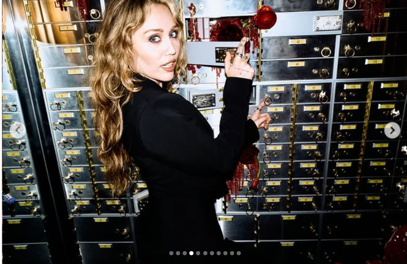 Miley Cyrus prend une pose à la fois espiègle et imposante devant un mur de coffres-forts métalliques, comme le montre sa publication datée du 25 octobre 2025 | Source : Instagram/mileycyrus