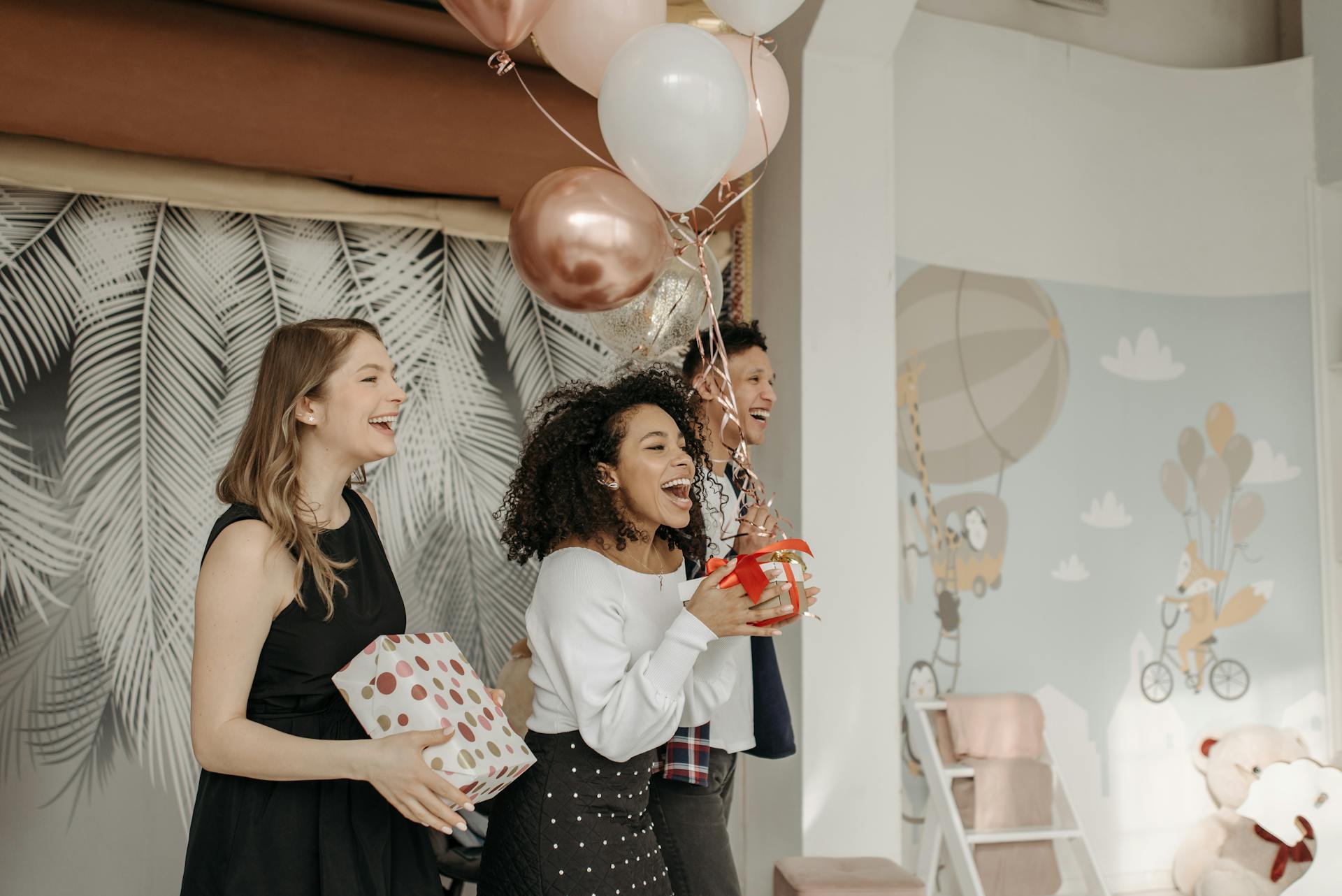 Des jeunes chantent un joyeux anniversaire en tenant des cadeaux et des ballons | Source : Pexels