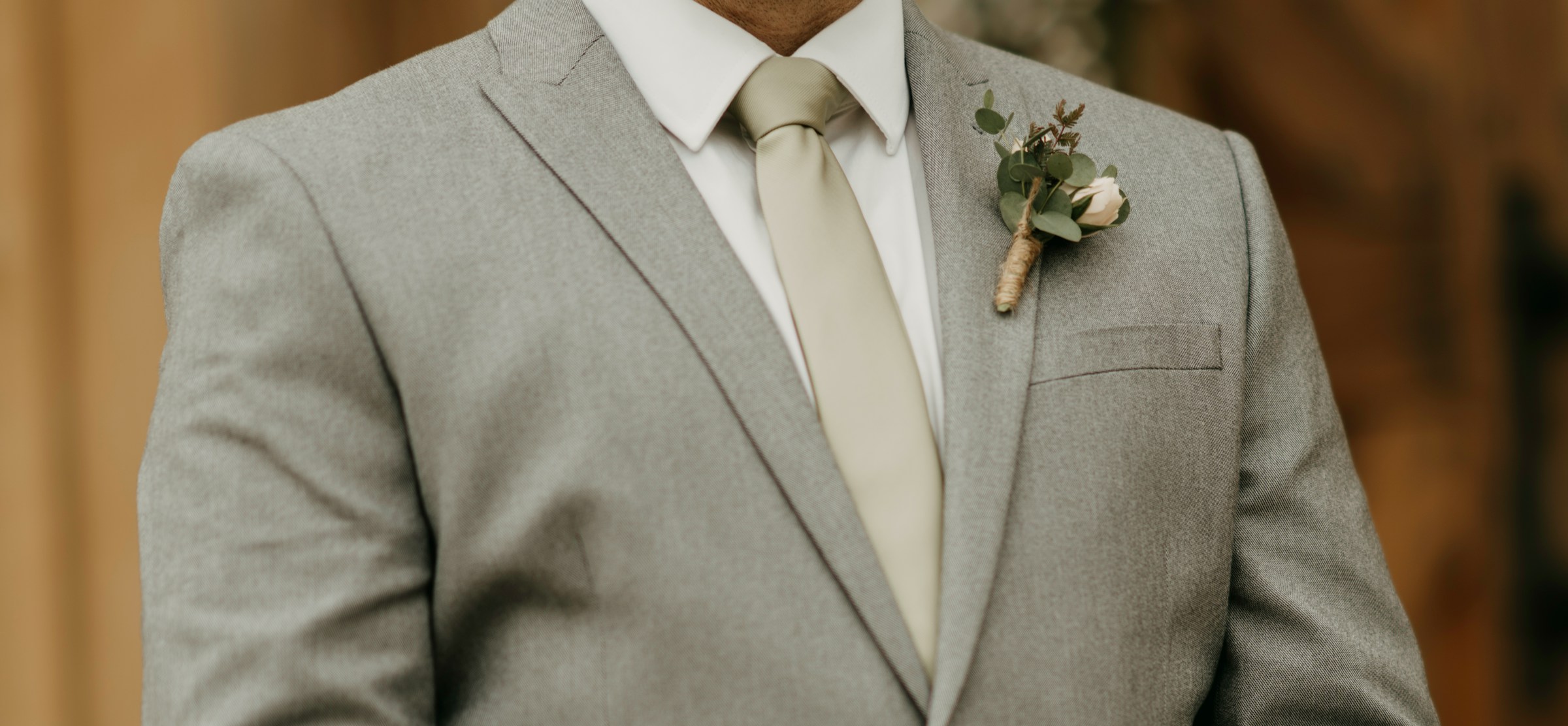Un homme en costume gris avec une boutonnière sur son revers | Source : Unsplash
