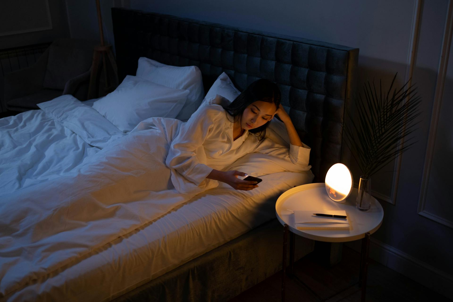 Une femme utilisant son téléphone dans son lit | Source : Pexels