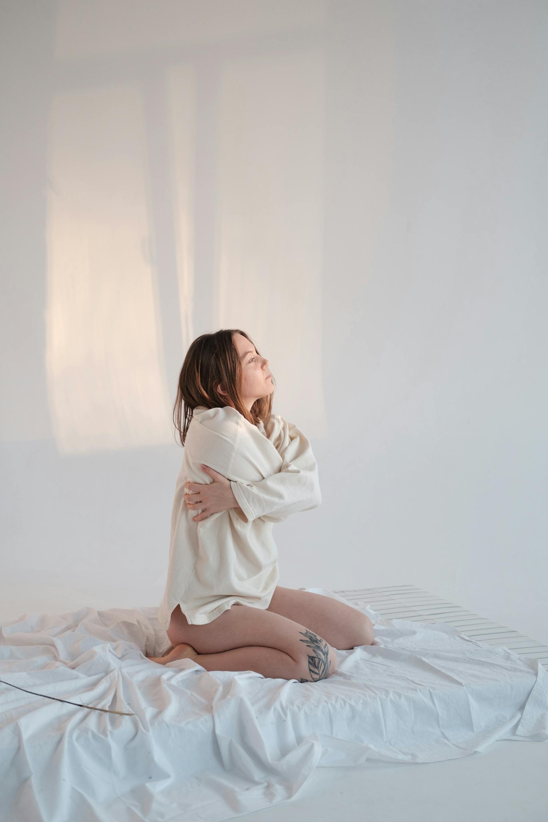 Une femme agenouillée sur un lit | Source : Pexels