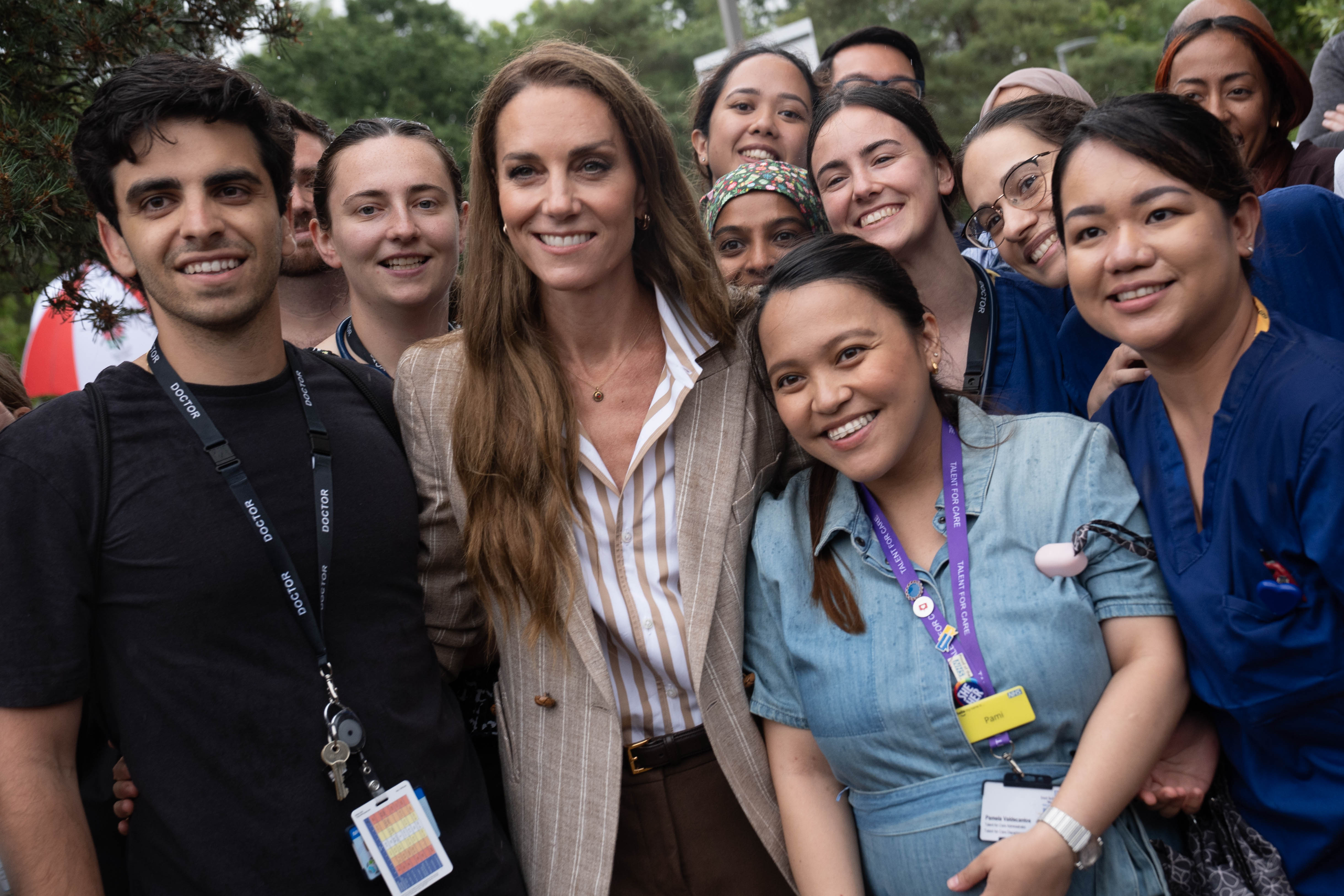 Entourée d'un personnel hospitalier rayonnant, la princesse Catherine pose pour une photo de groupe, son sourire reflétant la joie de ceux qui se sont tenus à ses côtés.