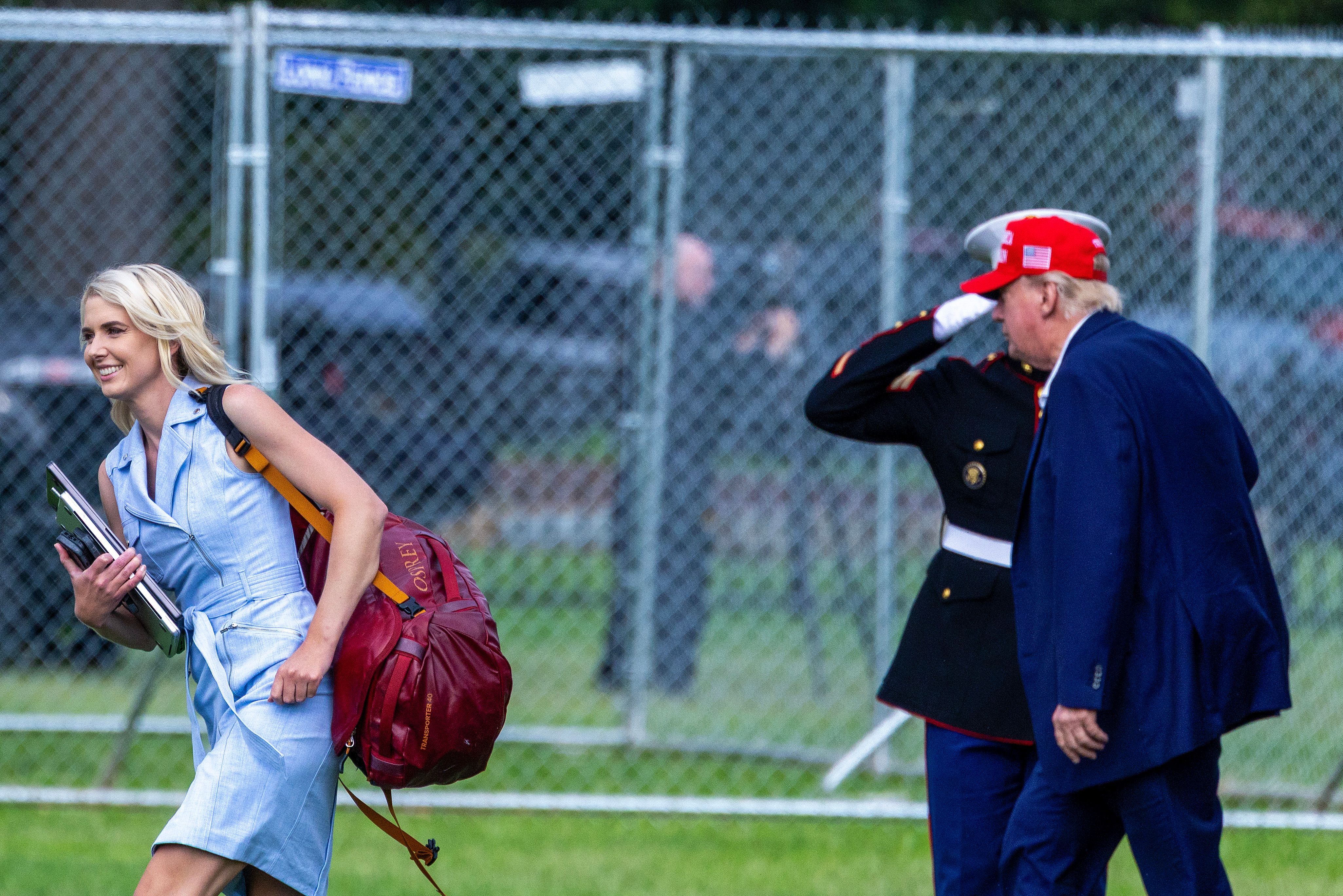 Natalie Harp marche devant Donald Trump, les documents à la main, documents qui ont joué un rôle déterminant dans son parcours à ses côtés. Leur proximité aurait suscité une attention croissante, notamment de la part des services secrets, alors que des inquiétudes concernant son comportement commençaient à faire surface. | Source : Getty Images