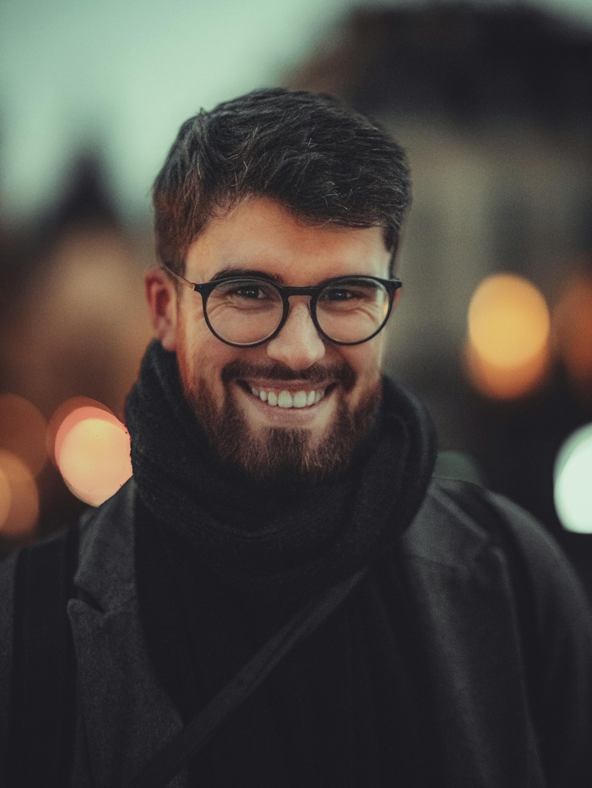 Un homme souriant portant des lunettes | Source : Pexels