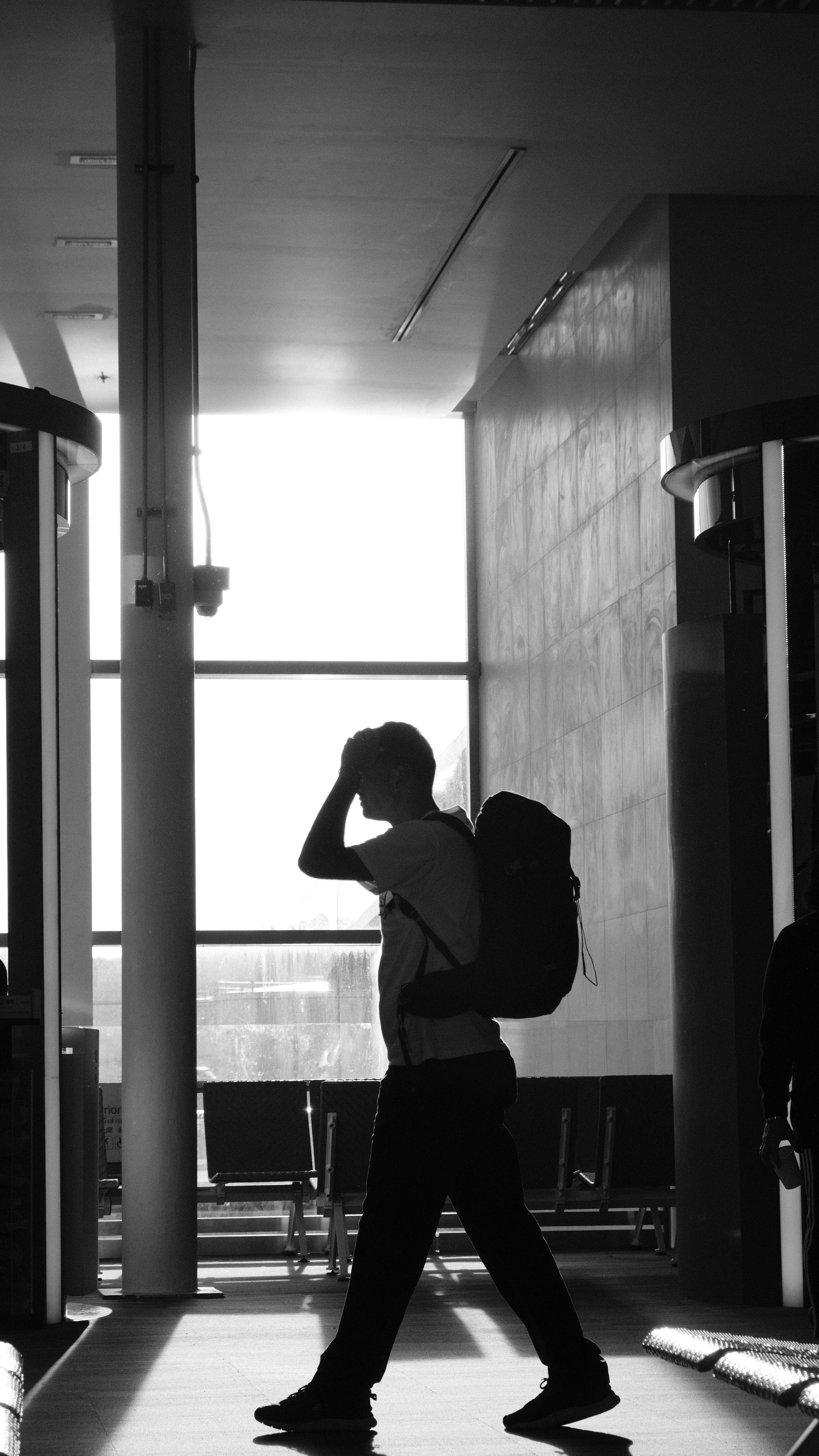 Homme avec un sac à dos dans un aéroport | Source : Pexels