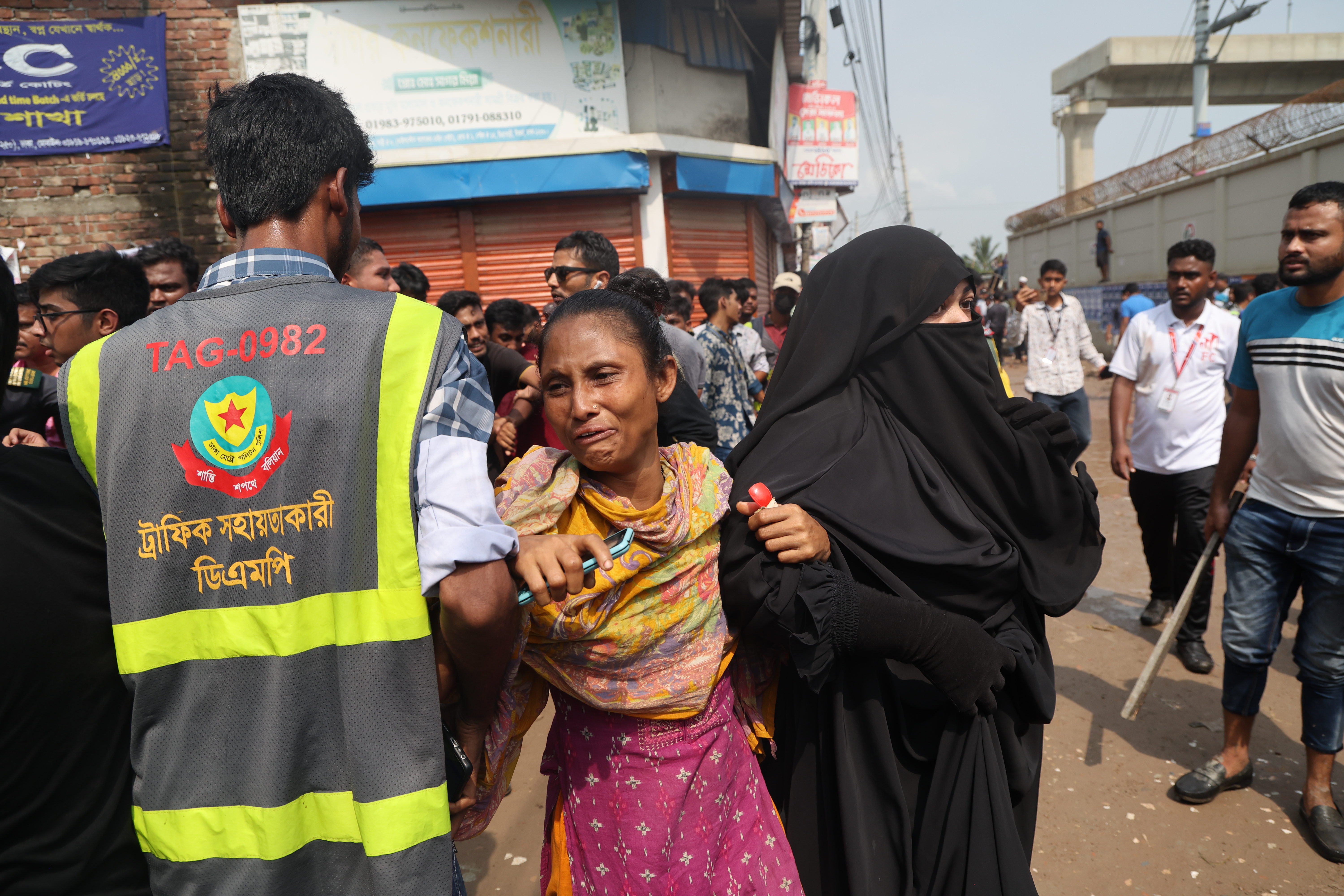 Des personnes réagissent alors qu'elles recherchent leurs proches après que l'avion F7 de l'armée de l'air du Bangladesh s'est écrasé sur un bâtiment du Milestone College à Uttara, à Dhaka, au Bangladesh, le 21 juillet 2025 | Source : Getty Images