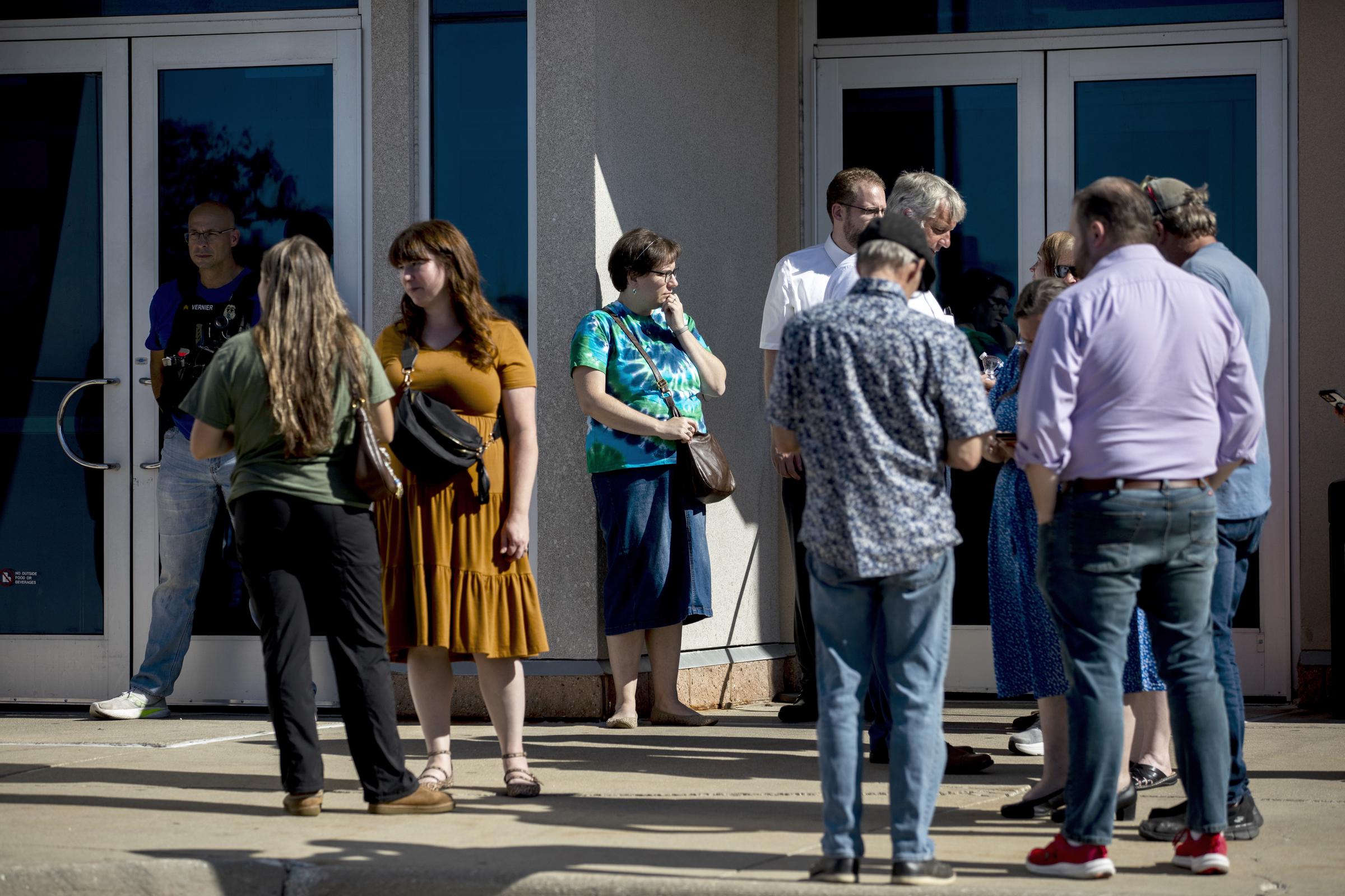 Les membres de l'église se réunissent au Trillium Theater, en face du site d'une fusillade et d'un incendie à l'Église de Jésus-Christ des Saints des Derniers Jours, le 28 septembre 2025 | Source : Getty Images