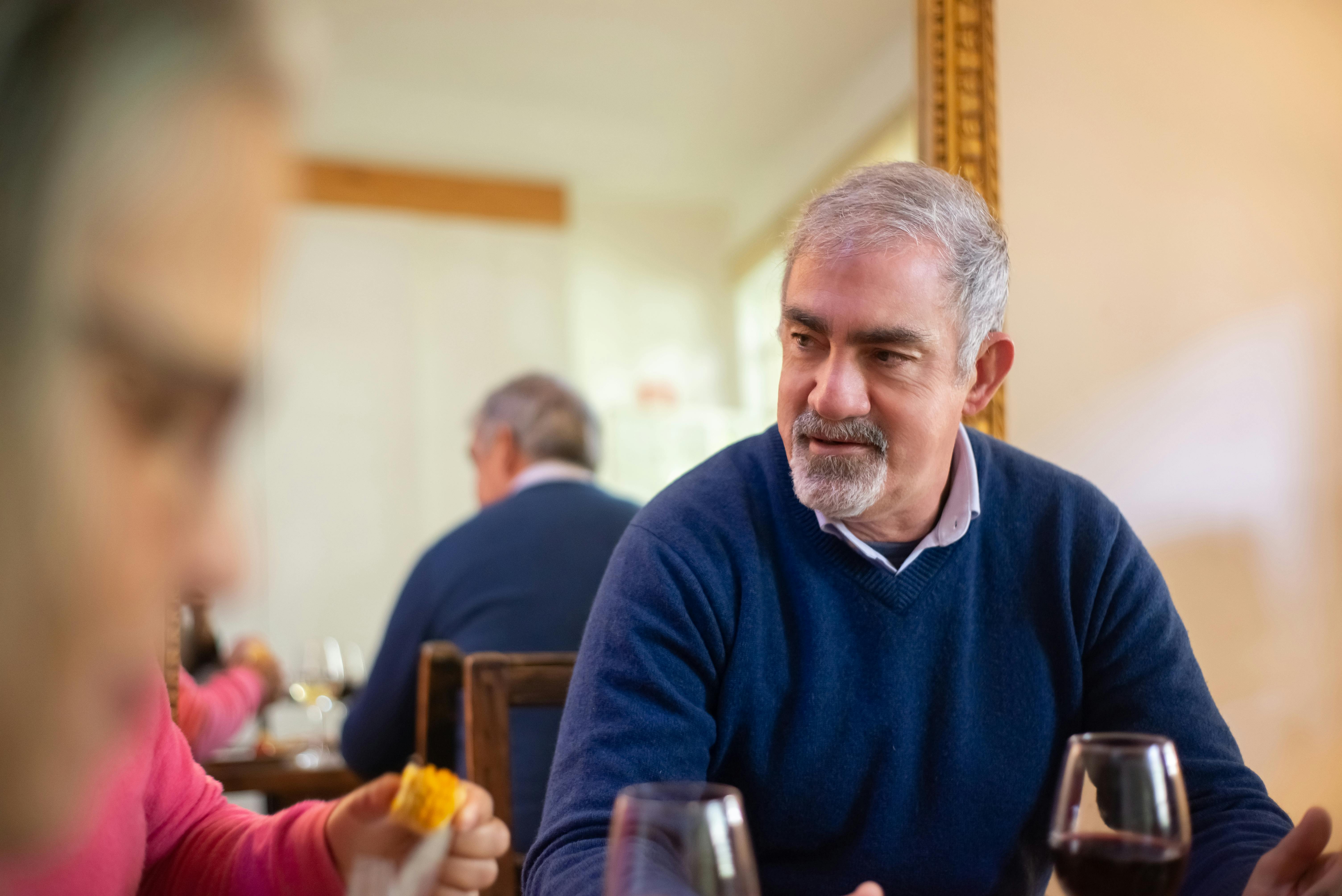 Un homme à l'expression faciale sérieuse assis à une table de dîner | Source : Pexels