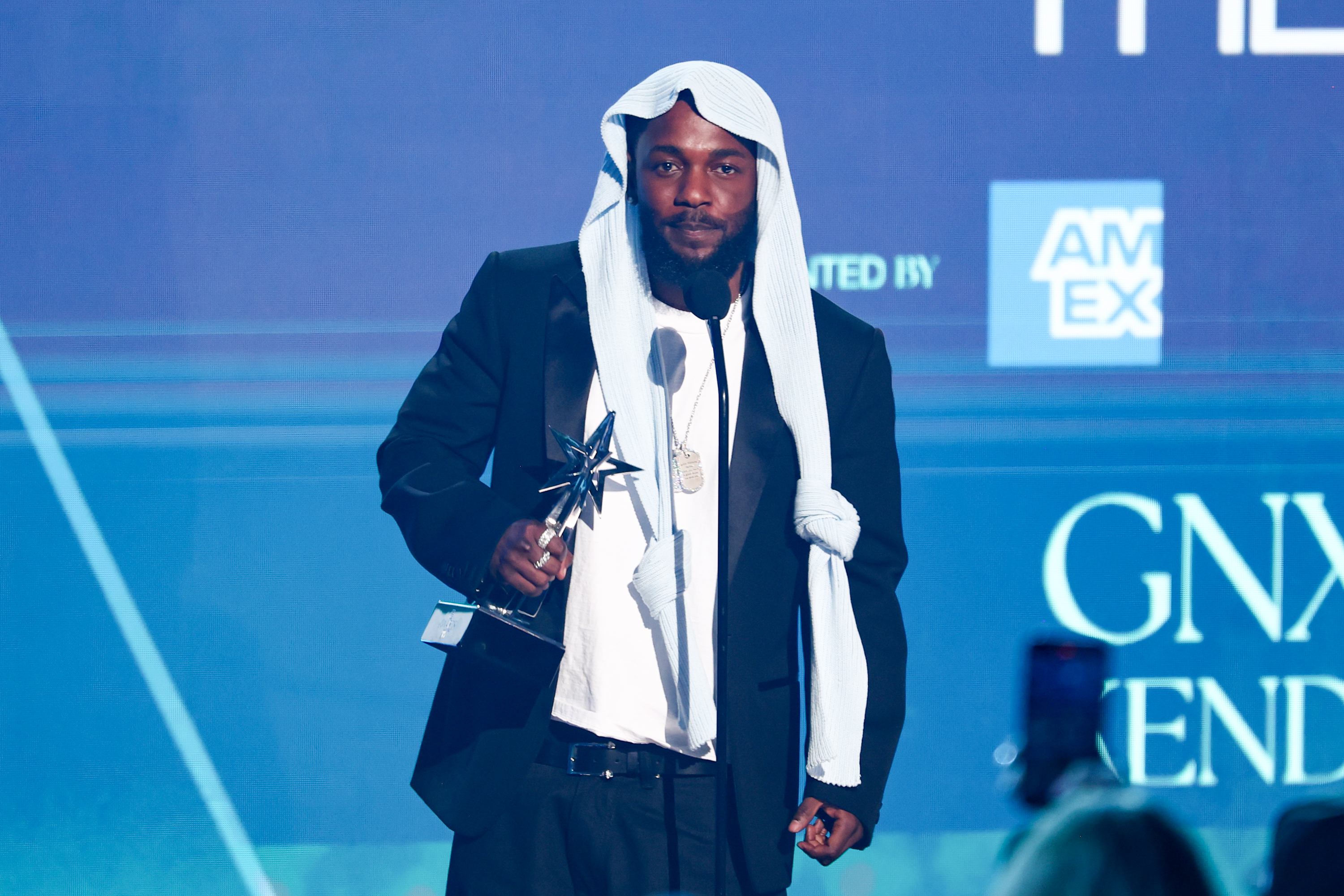 Kendrick Lamar accepte l'un de ses cinq BET Awards en portant un costume noir et une coiffe qui a déclenché un buzz viral en ligne. Le moment s'est déroulé sur la scène du Peacock Theater lors des 2025 BET Awards à Los Angeles, en Californie.