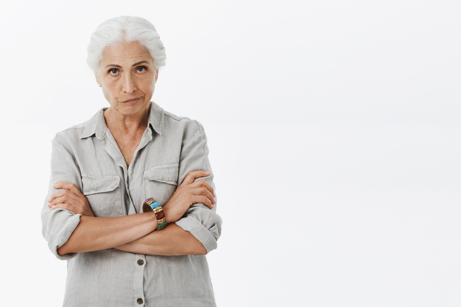 Une femme âgée mécontente croisant les bras et regardant fixement | Source : Freepik