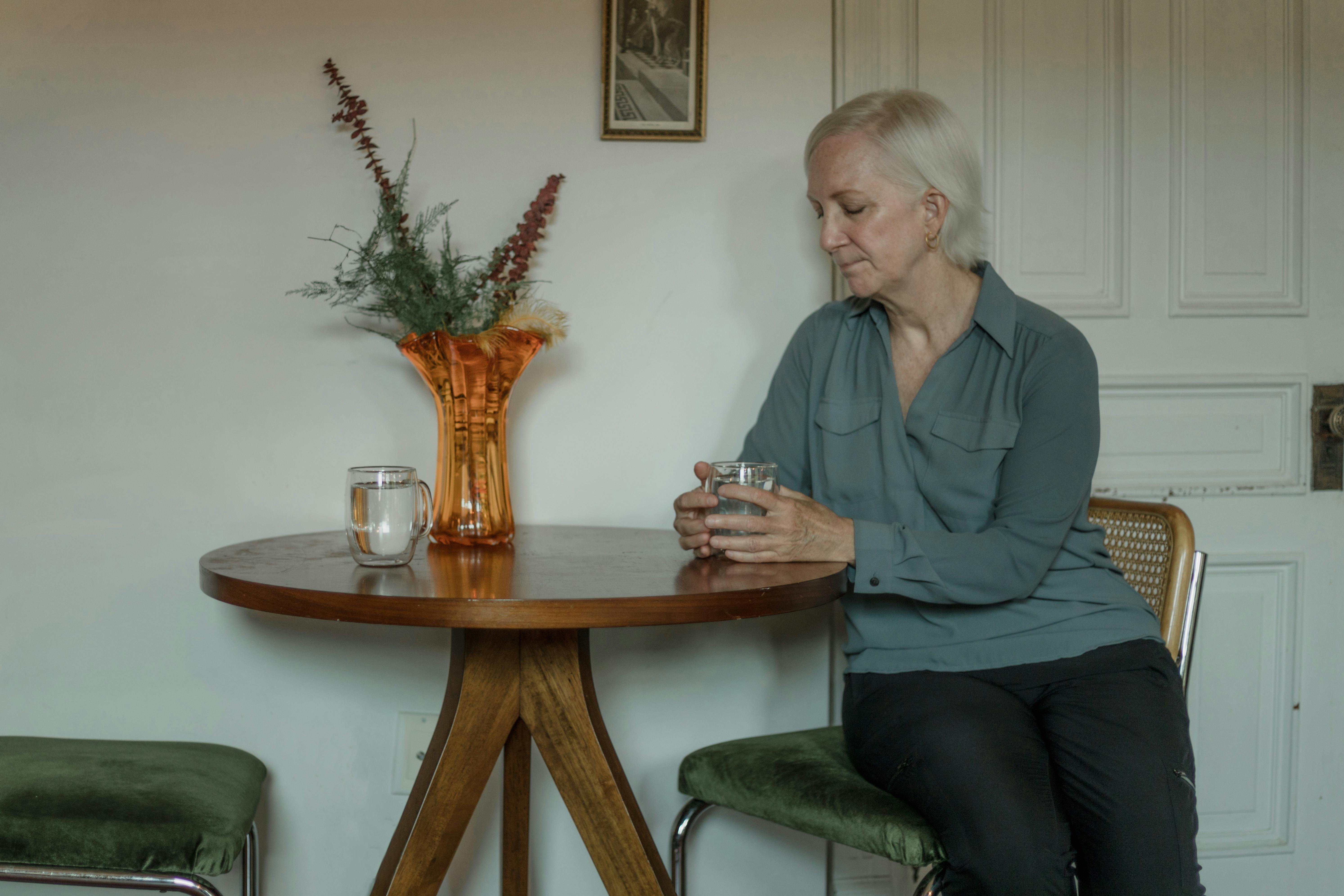 Une femme âgée assise à une table | Source : Pexels