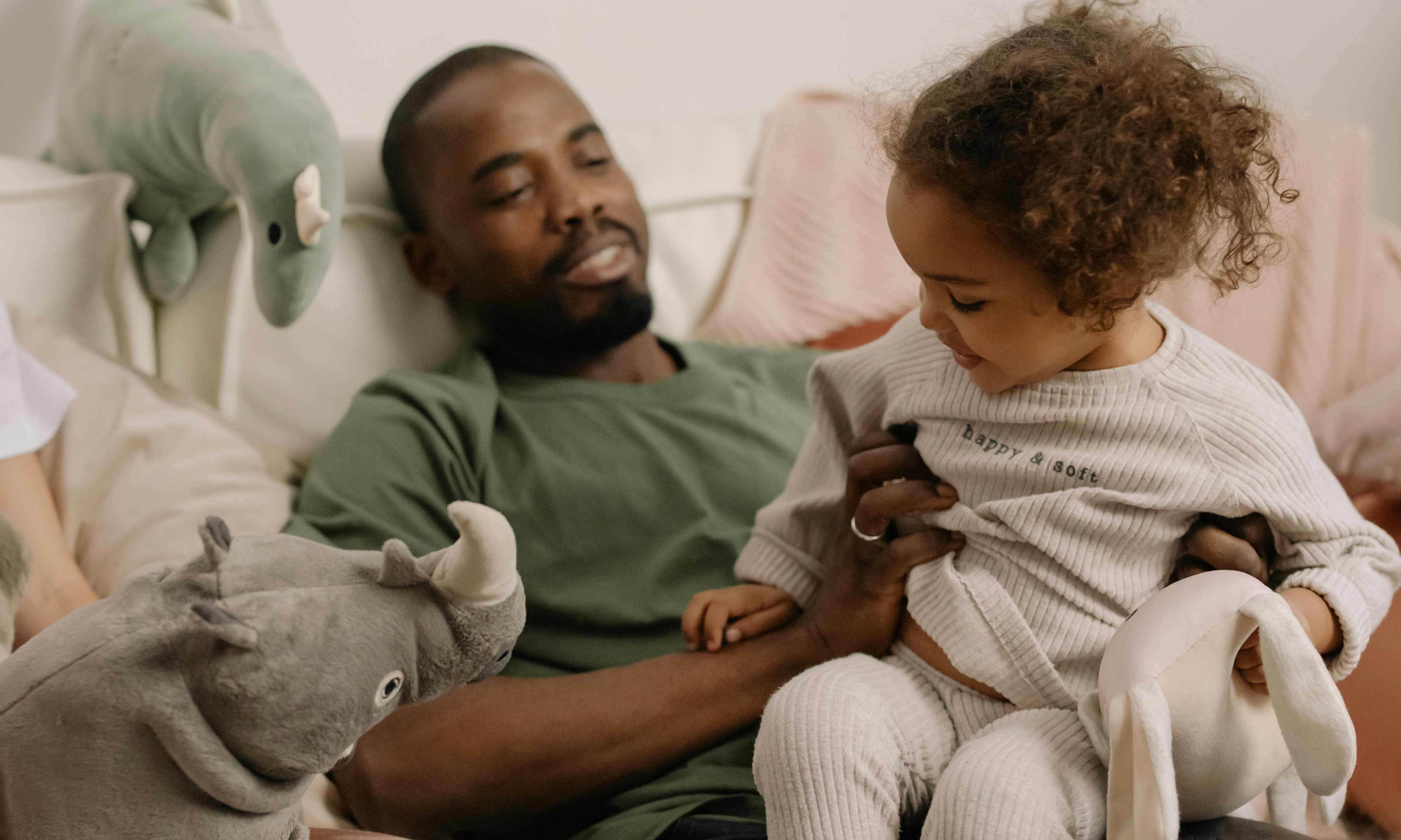 Un homme avec un enfant sur ses genoux | Source : Pexels