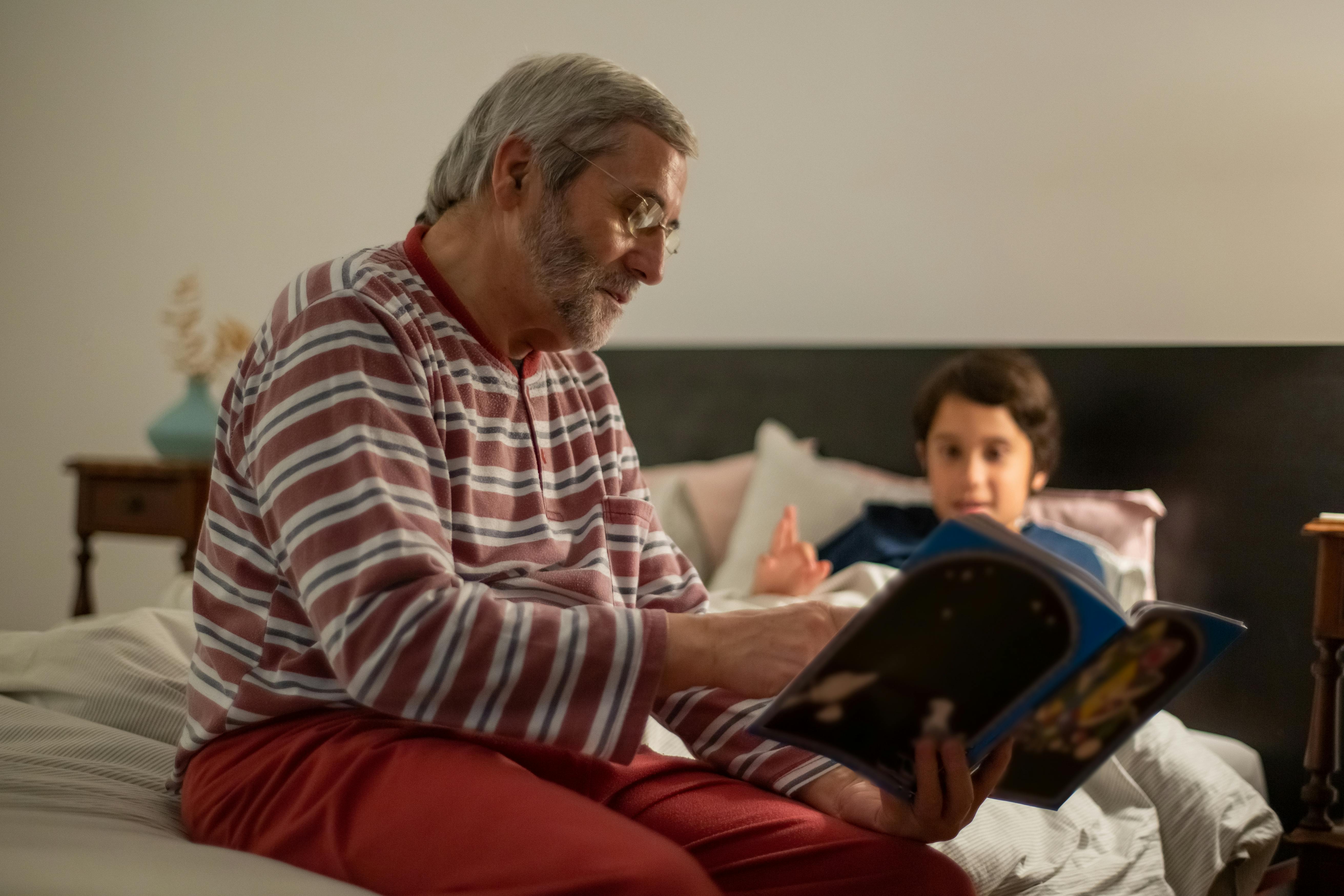 Un homme qui lit un livre à un enfant | Source : Pexels