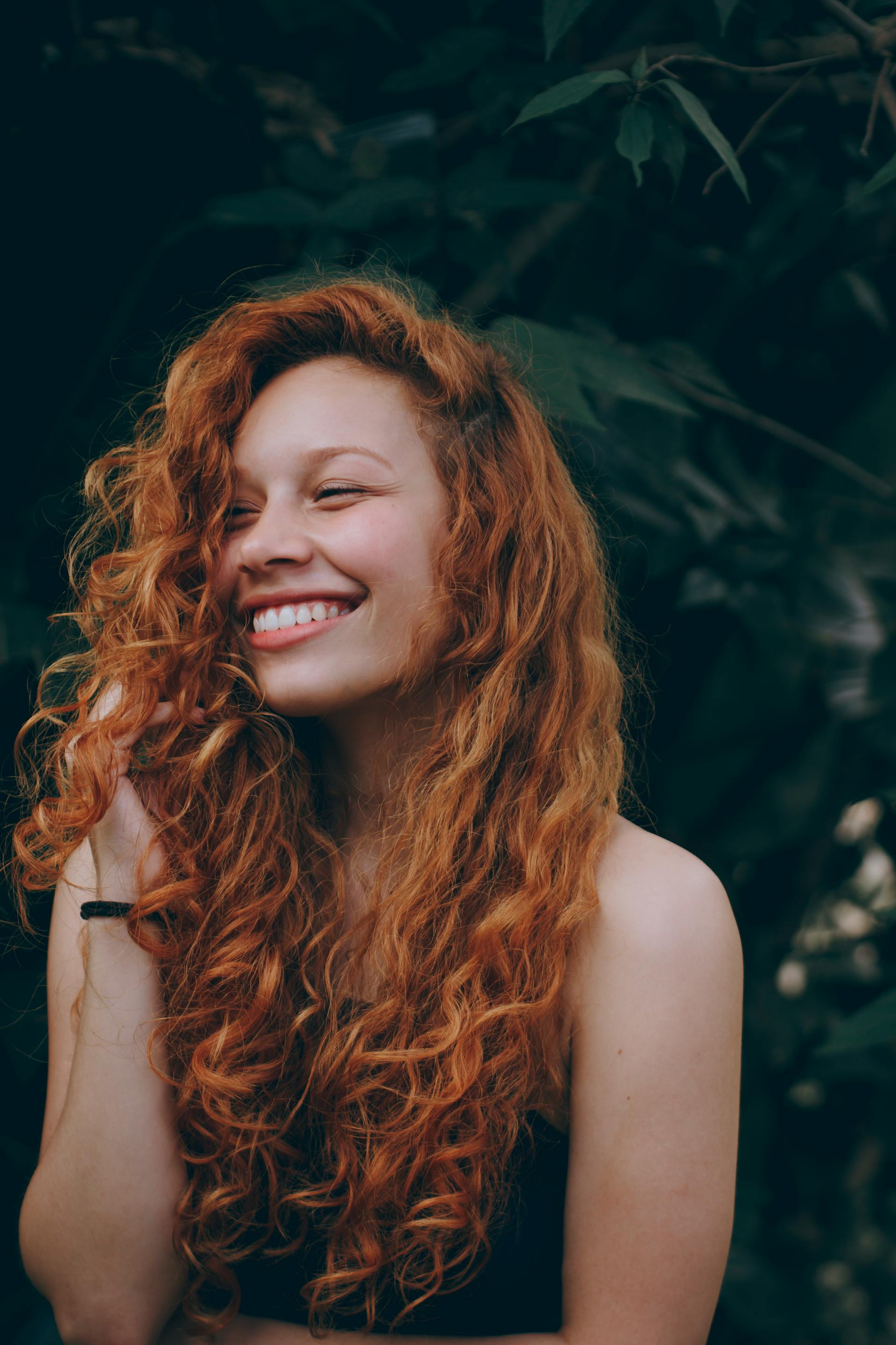 Une femme souriante aux cheveux roux | Source : Pexels
