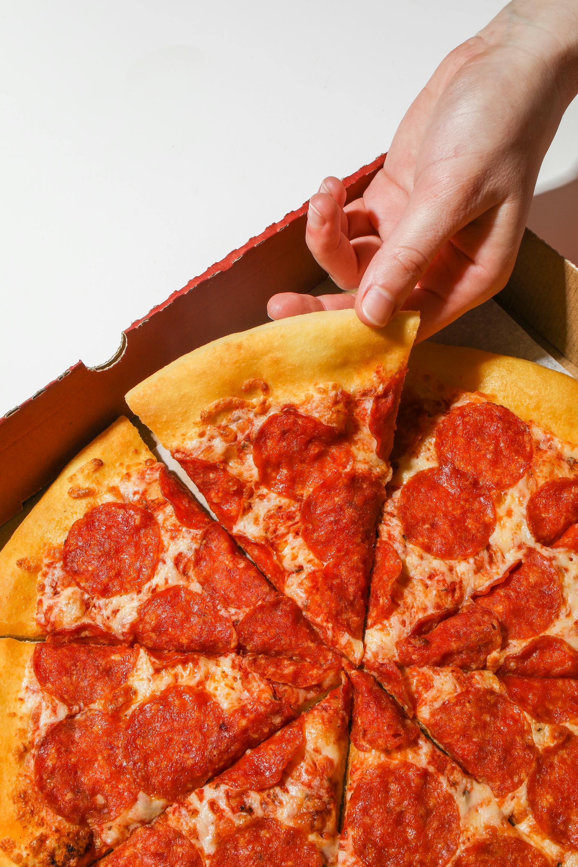 Une personne tenant une part de pizza | Source : Pexels