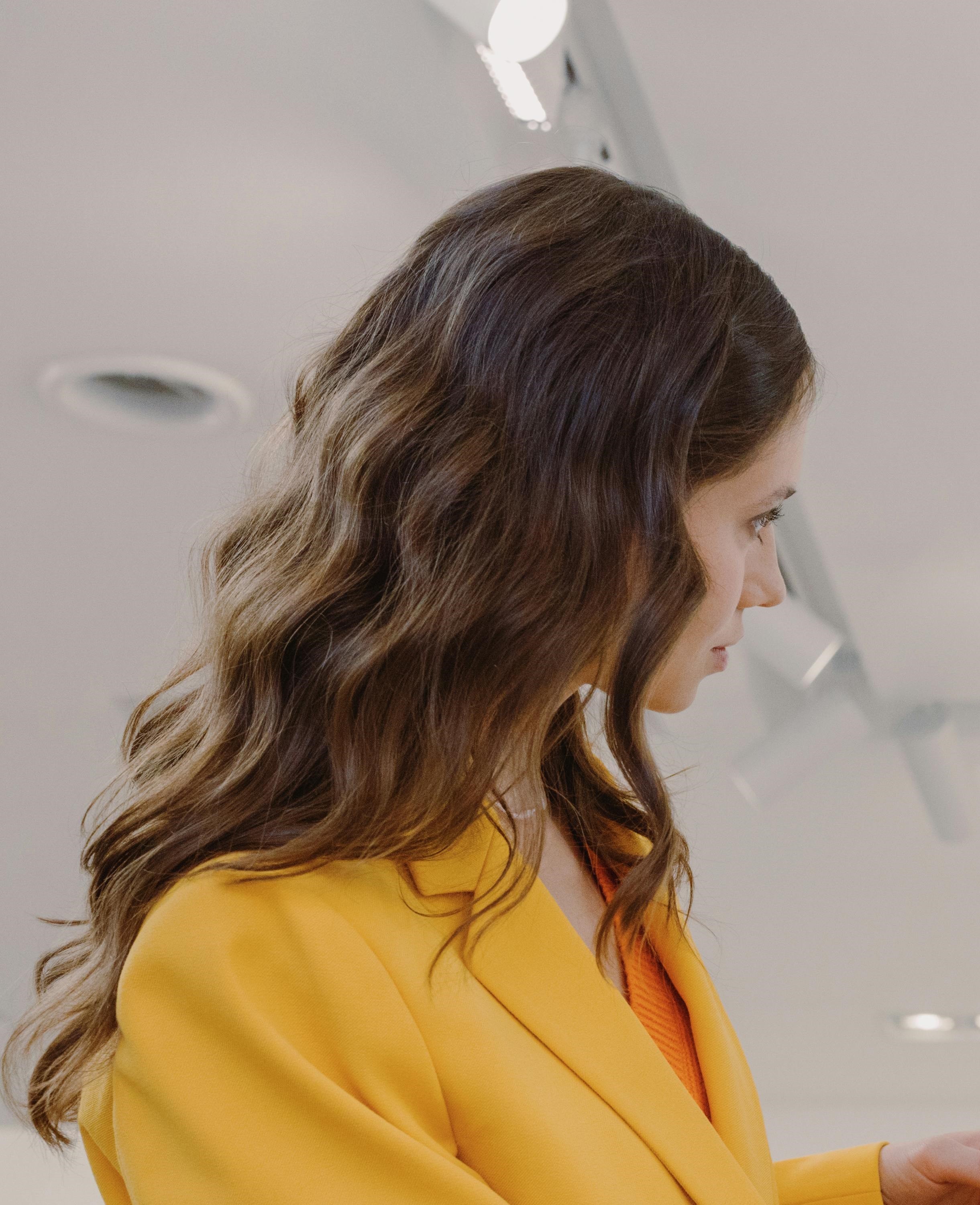 Une femme en tailleur jaune vif parle à quelqu'un | Source : Pexels