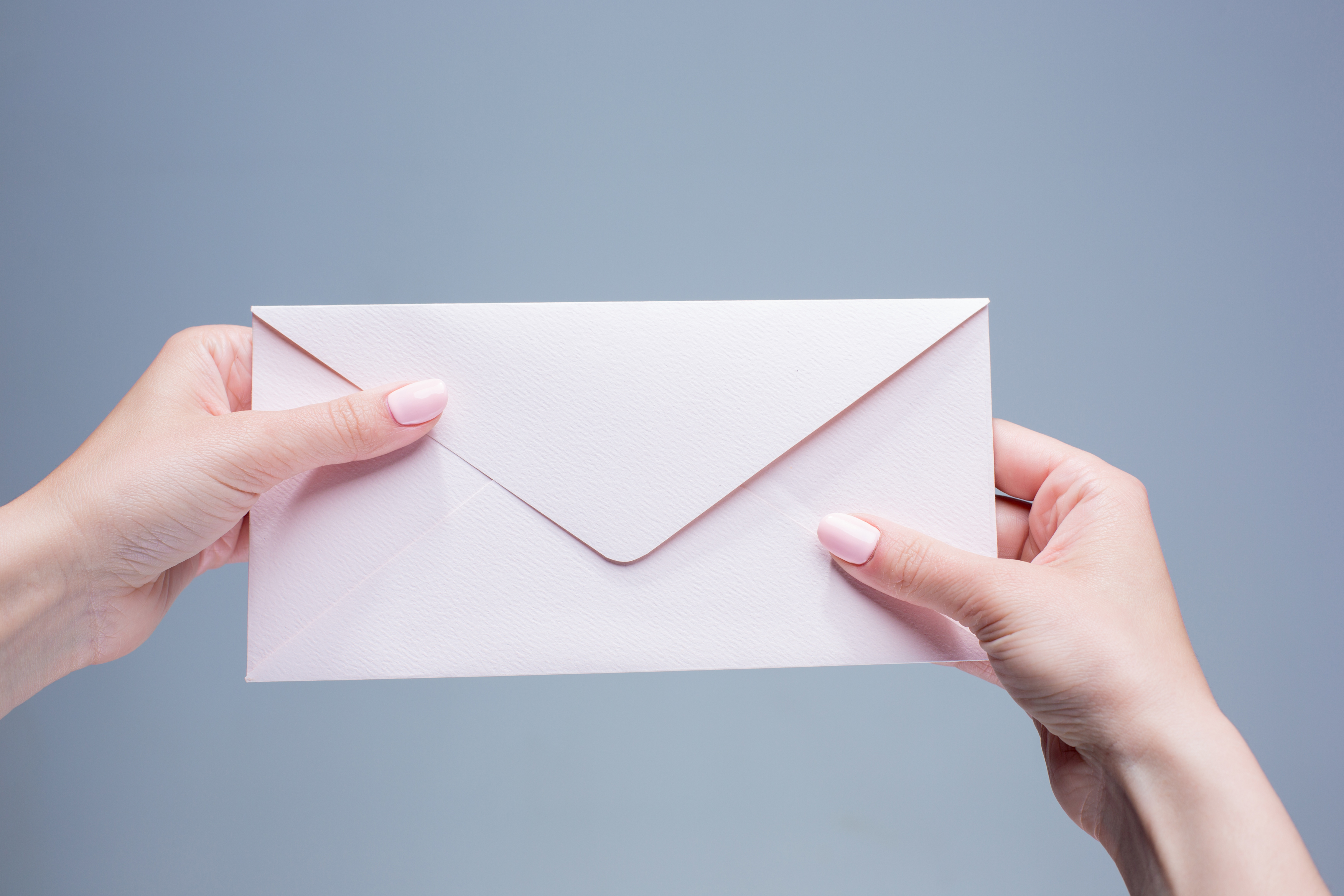 Gros plan des mains d'une femme tenant une enveloppe | Source : Freepik
