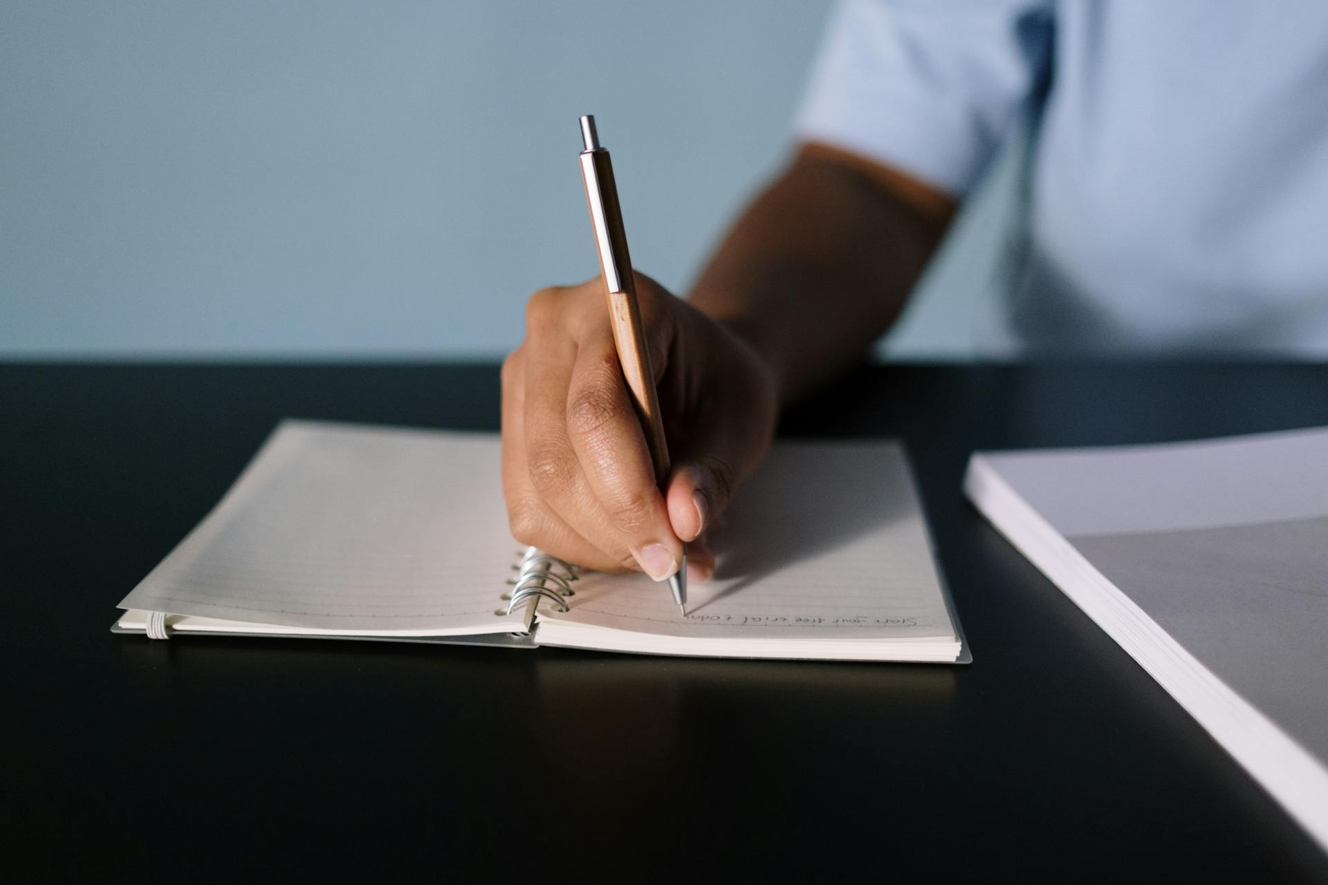 Un garçon qui écrit sur une feuille de papier | Source : Pexels