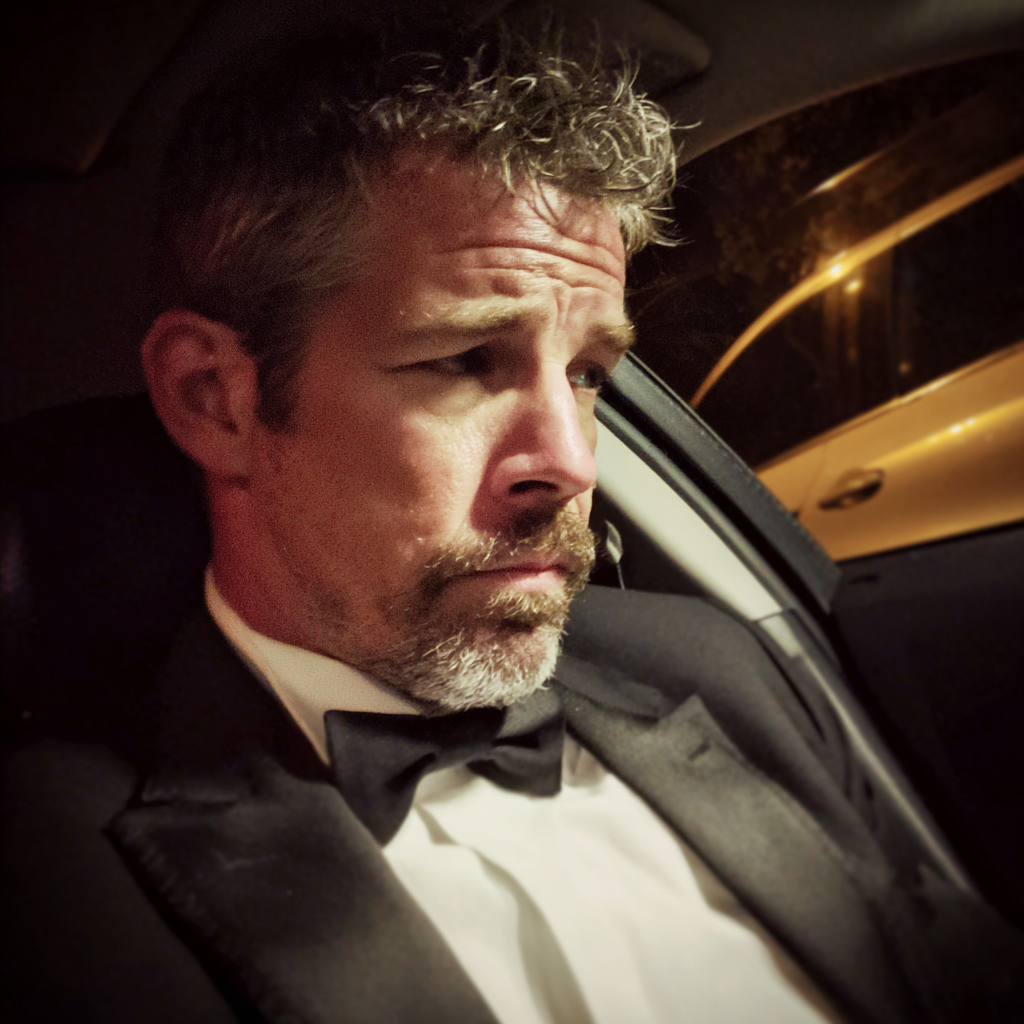 Un homme portant un smoking et assis dans une voiture | Source : Midjourney