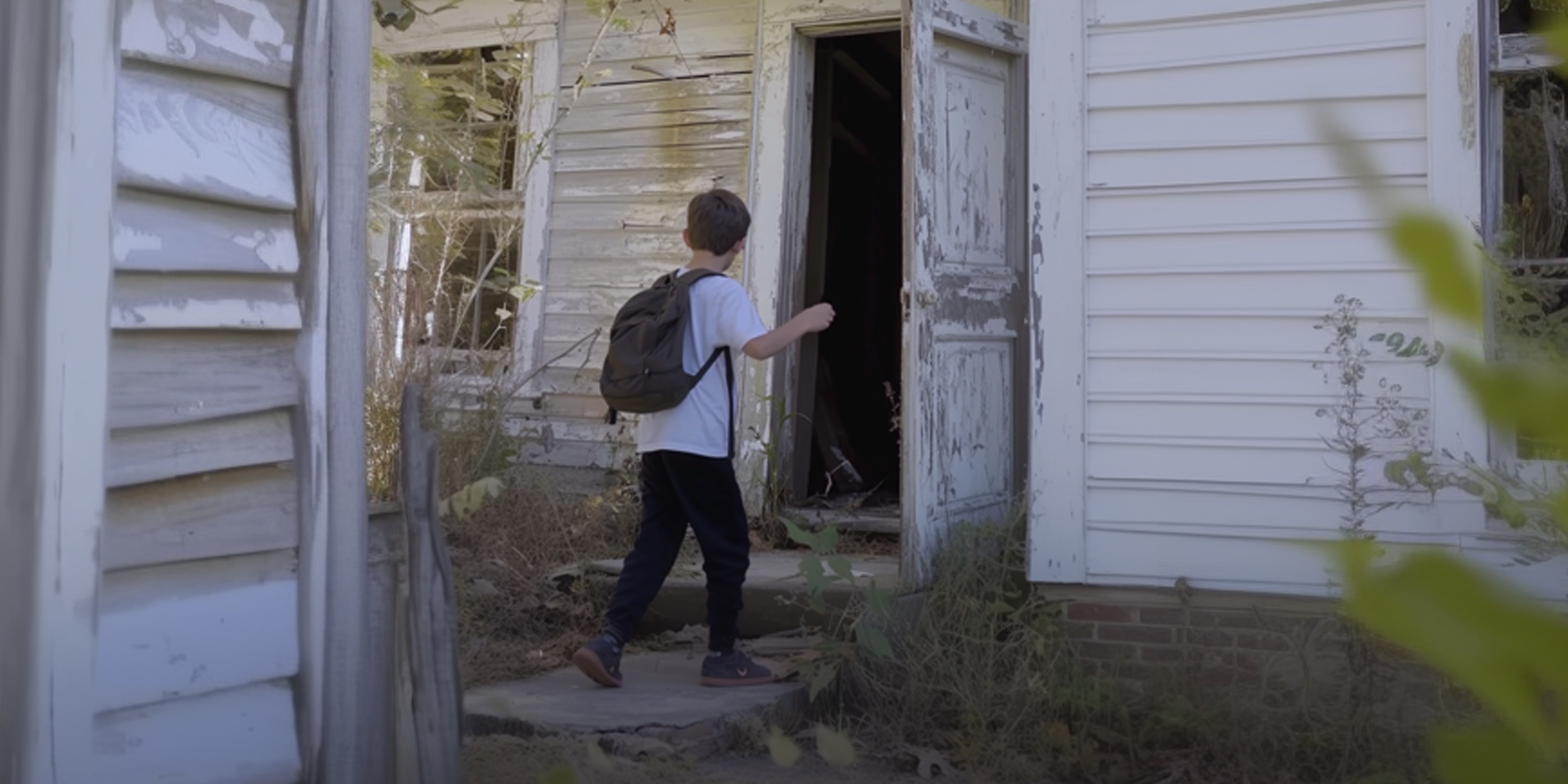 Un garçon s'approchant d'un bâtiment abandonné | Source : Ozdomedia