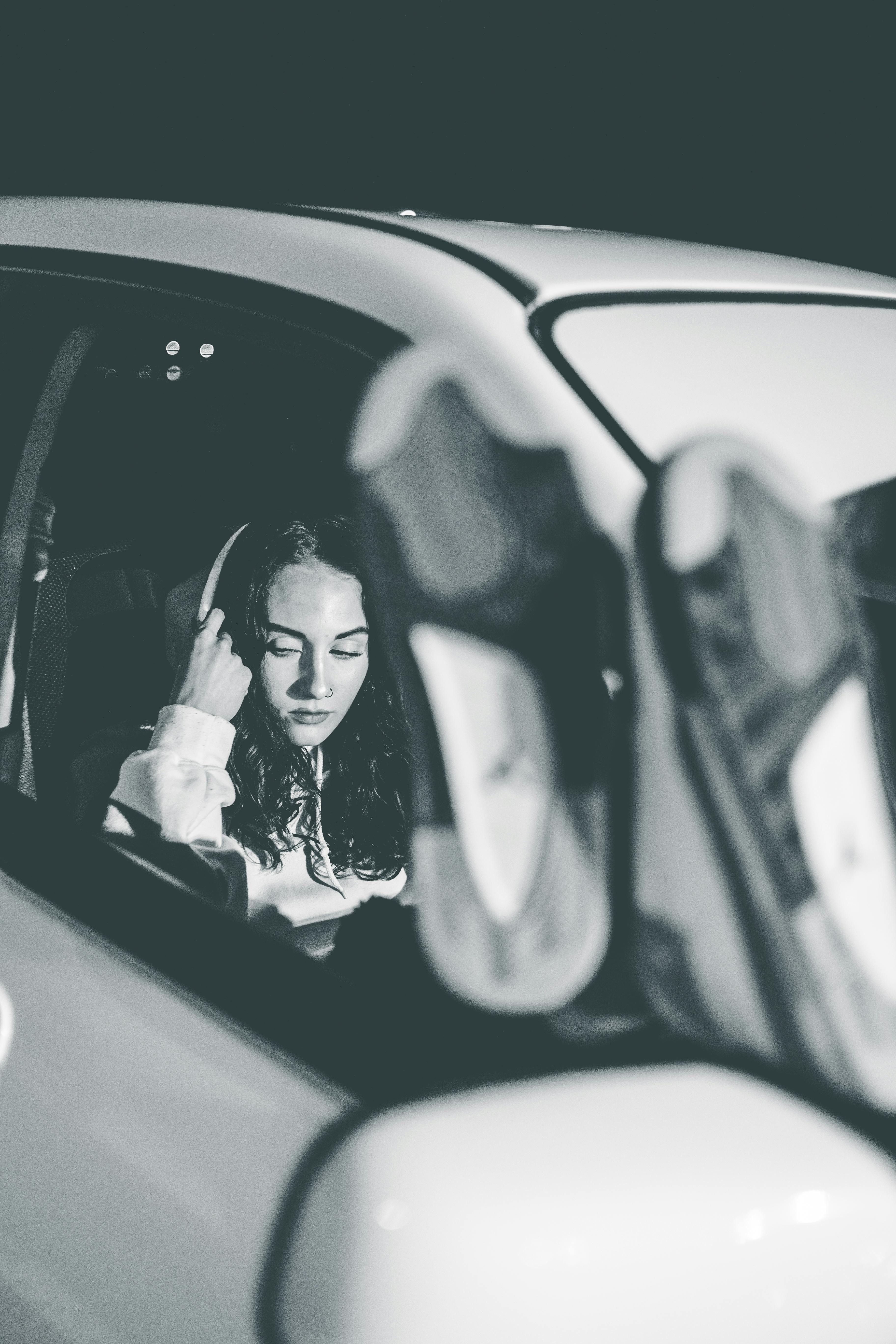Une femme sérieuse assise sur le siège passager d'une voiture | Source : Pexels