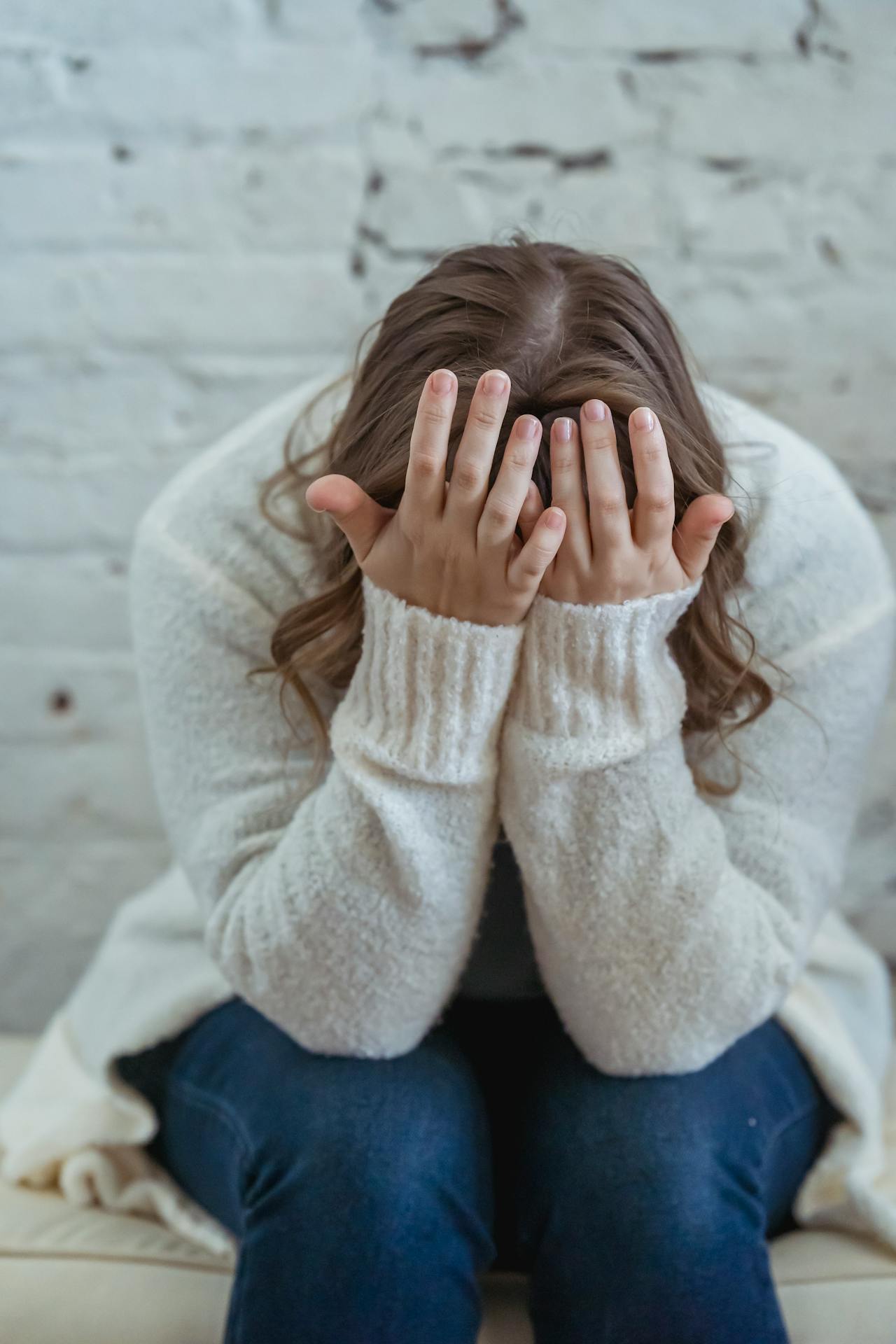 Une femme triste assise sur le canapé | Source : Pexels