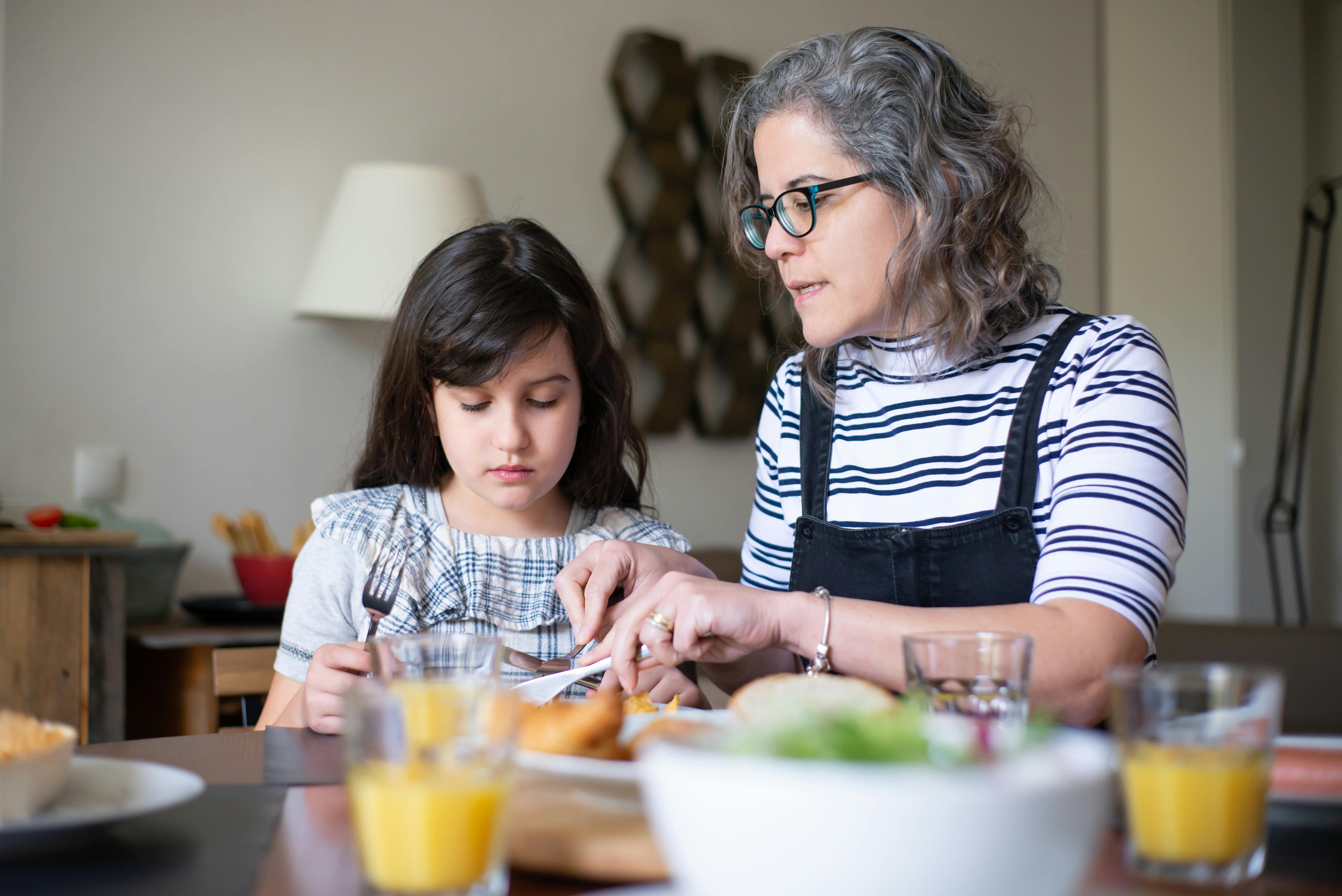 Une femme discutant avec une jeune fille à table | Source : Pexels