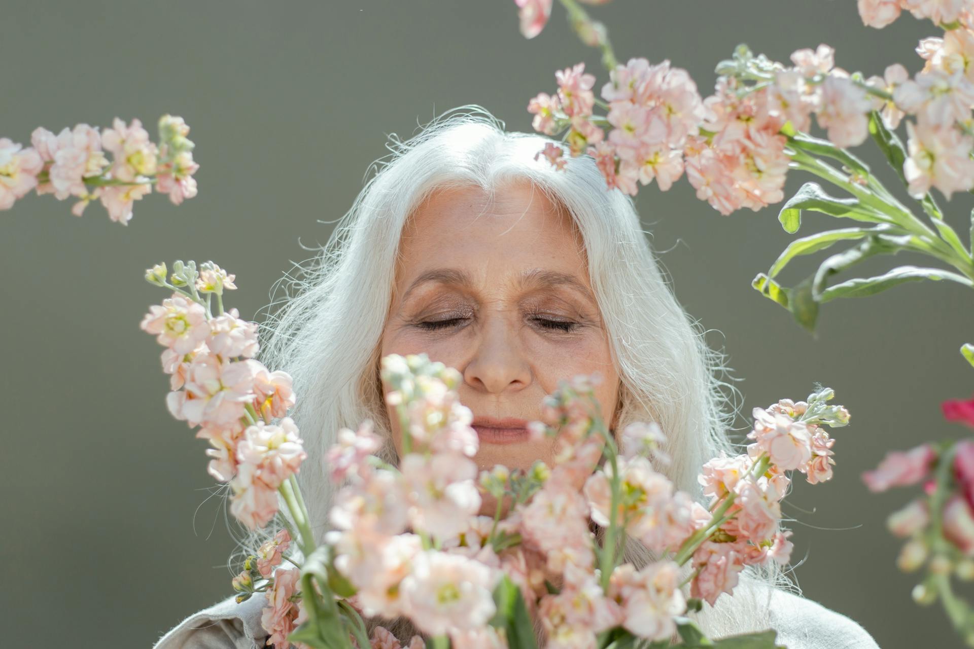 Femme mûre sentant des fleurs | Source : Pexels