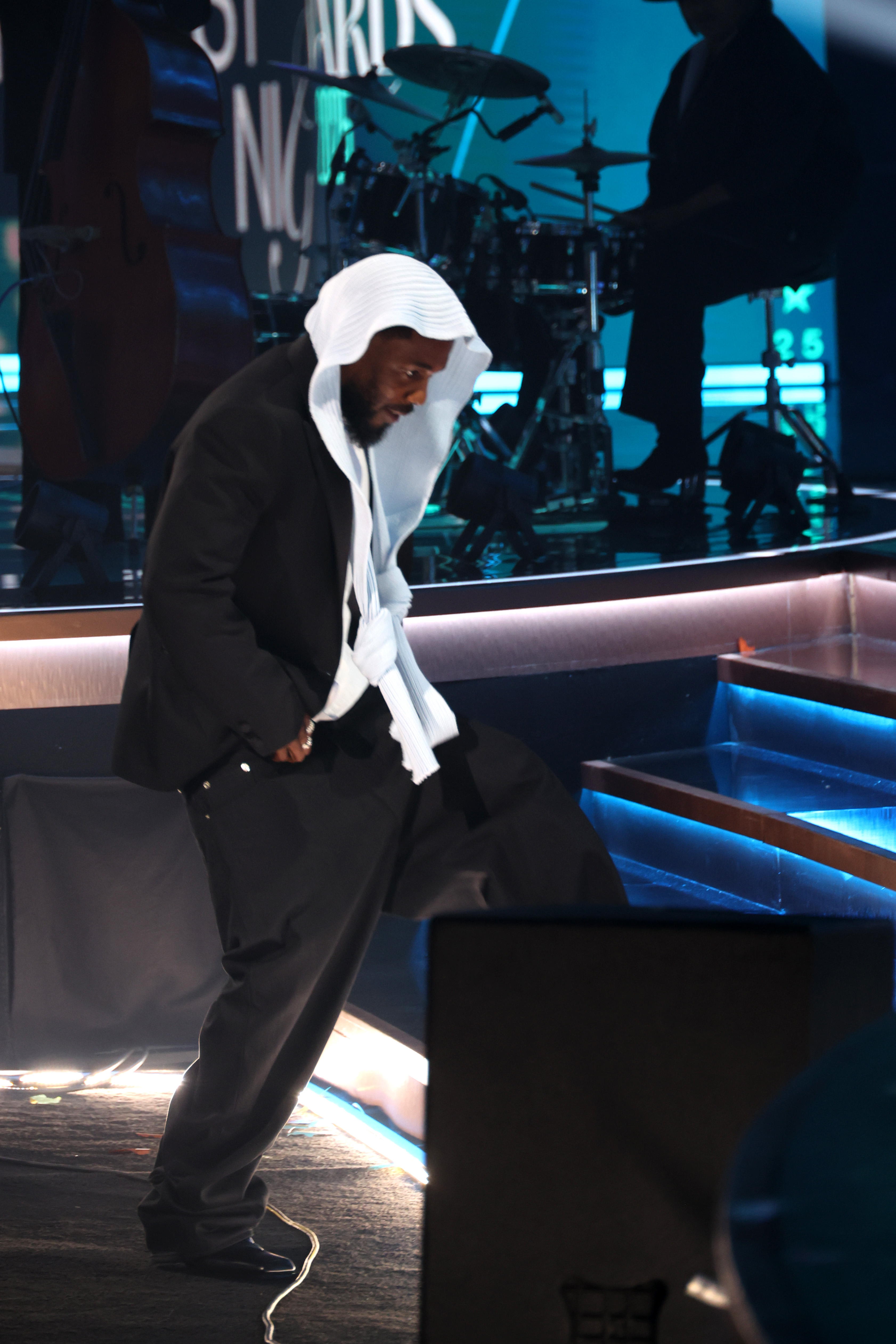 Kendrick Lamar monte sur scène lors de la cérémonie des BET Awards 2025. Le rappeur, connu pour son calme caractéristique, a gardé la tête légèrement inclinée alors qu'il montait les marches pour accepter l'un de ses prix.