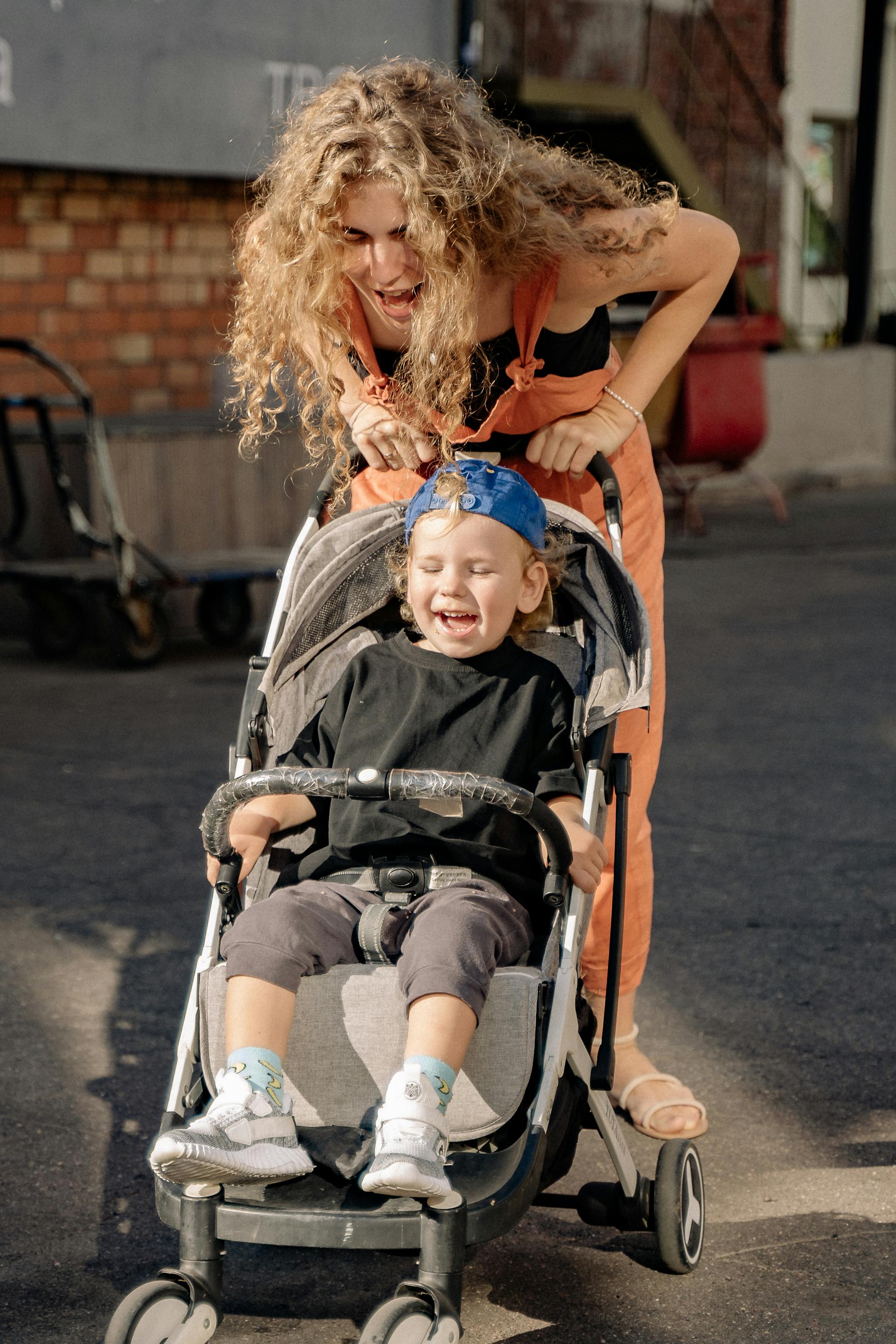 Une femme s'amusant avec son fils dans une poussette | Source : Pexels