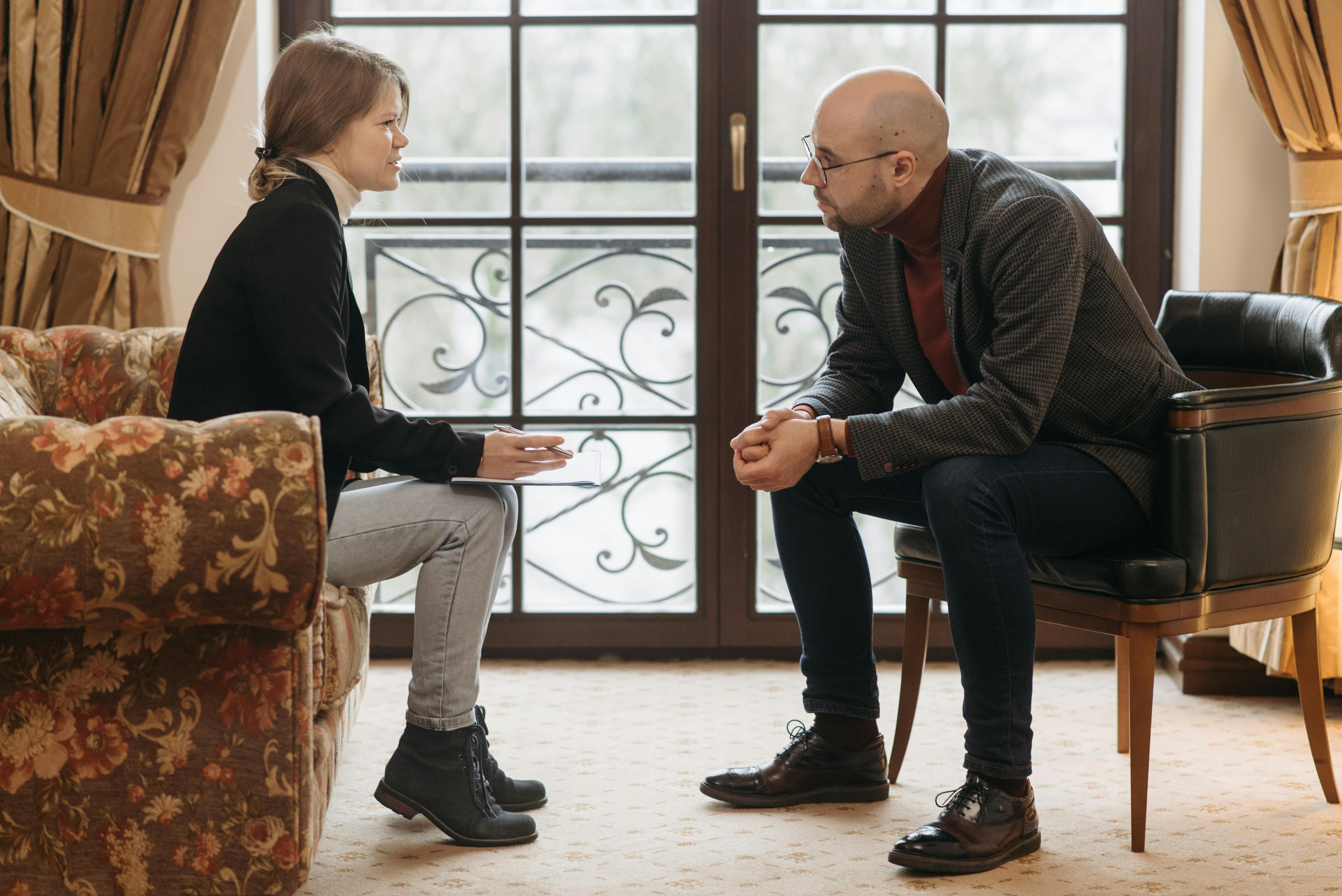 Un homme qui se penche près d'une femme alors qu'il lui parle | Source : Pexels