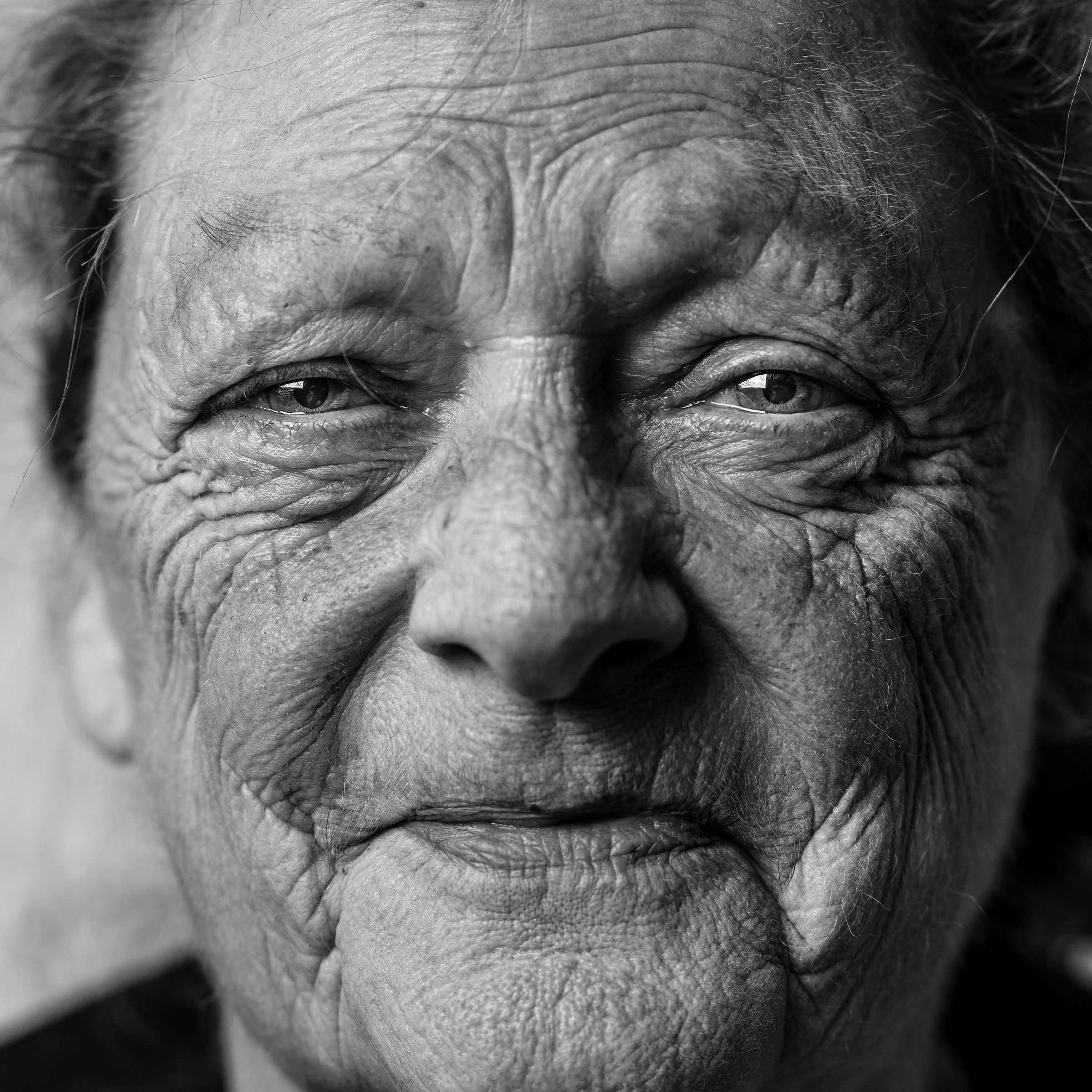 Photo en niveaux de gris d'une femme âgée souriante | Source : Unsplash