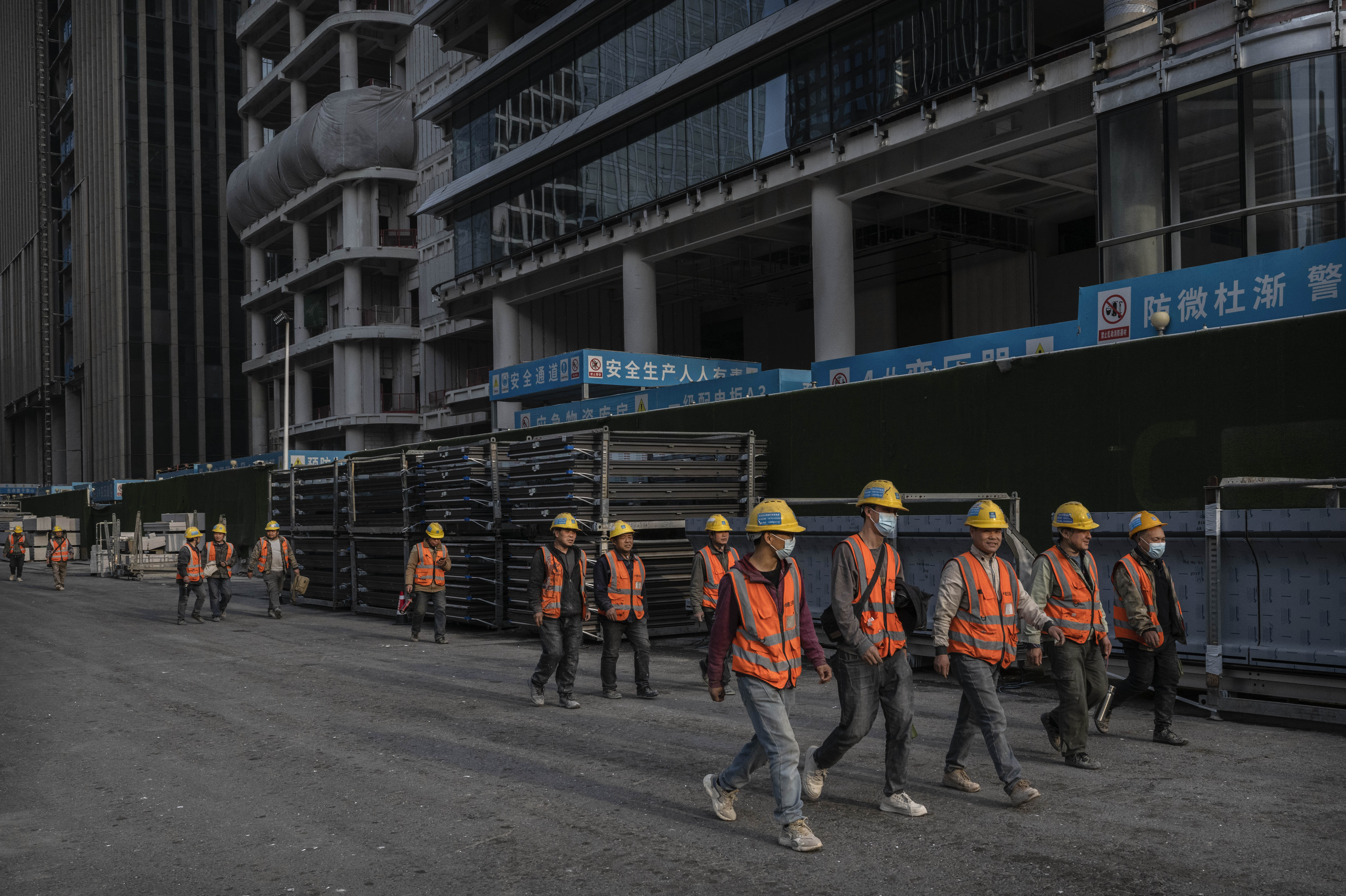 Des ouvriers du bâtiment quittent un chantier dans le quartier central des affaires à Pékin, en Chine, le 10 avril 2025 | Source : Getty Images