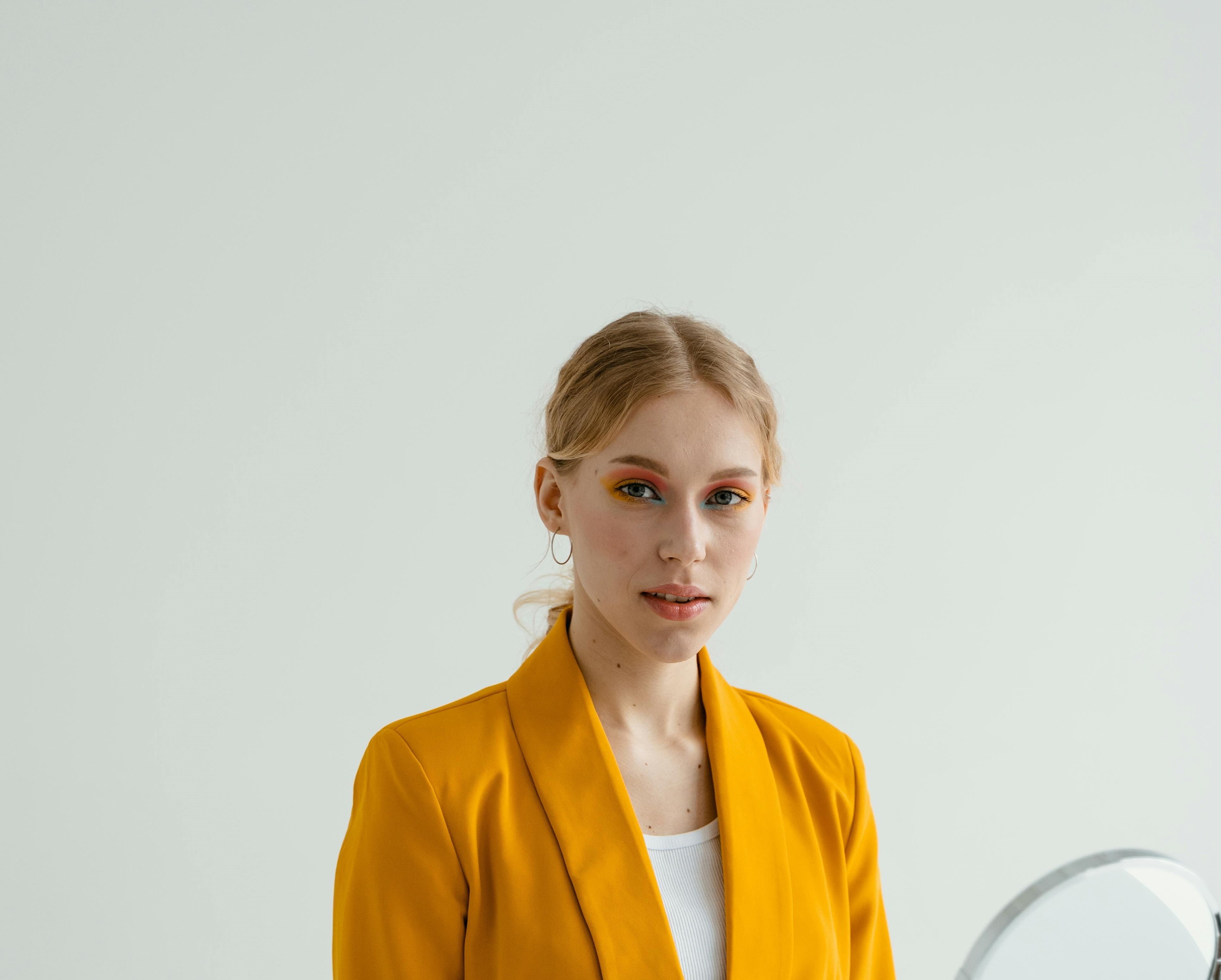 Femme en costume jaune vif souriant | Source : Pexels