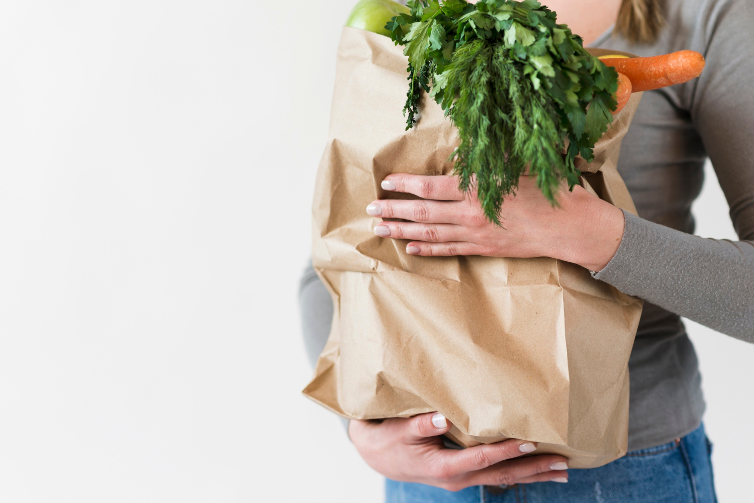 Une femme tenant un sac de provisions | Source : Freepik